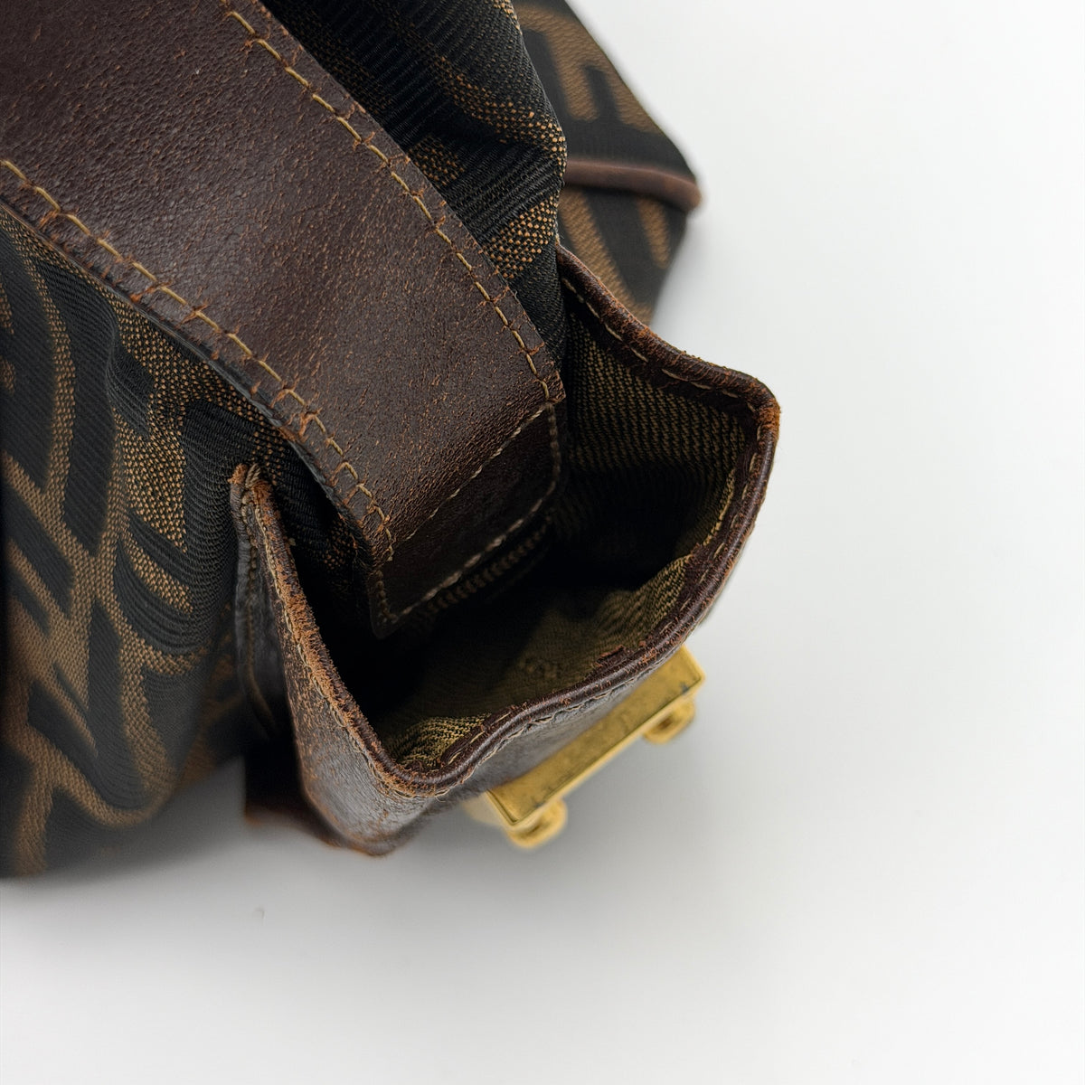 Fendi FF Zucca Double Zip Tote Bag in brown monogram canvas with leather straps and side pocket detail, shown on a yellow dust bag.