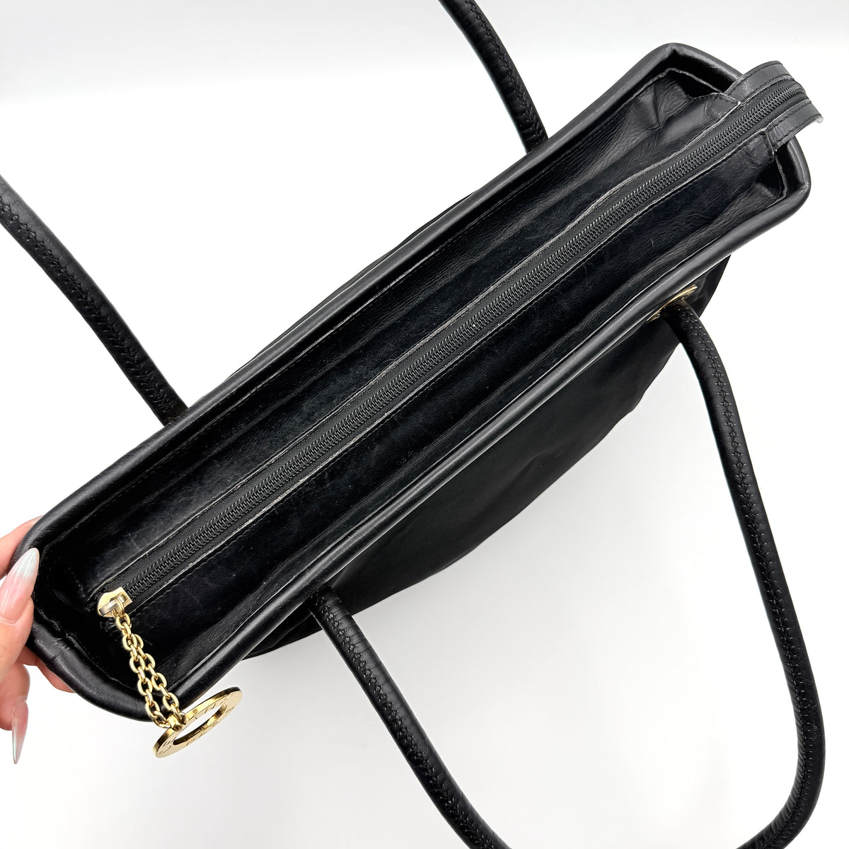 Black Celine nylon tote bag with gold circle logo hardware and leather handles, photographed flat on a white background.