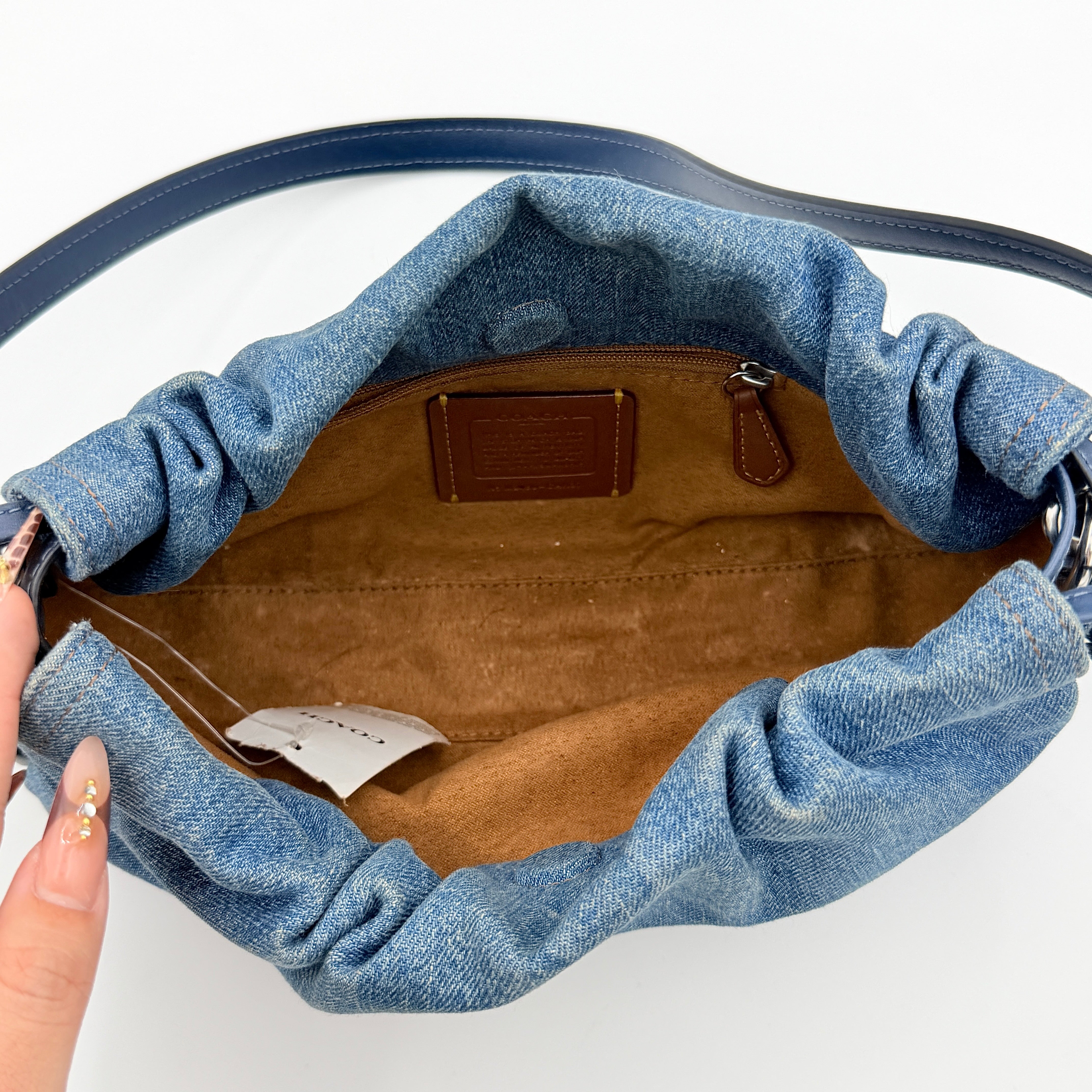 Coach Faye Shoulder Bag in blue denim with navy leather strap and detachable crossbody, styled simply against a white background.