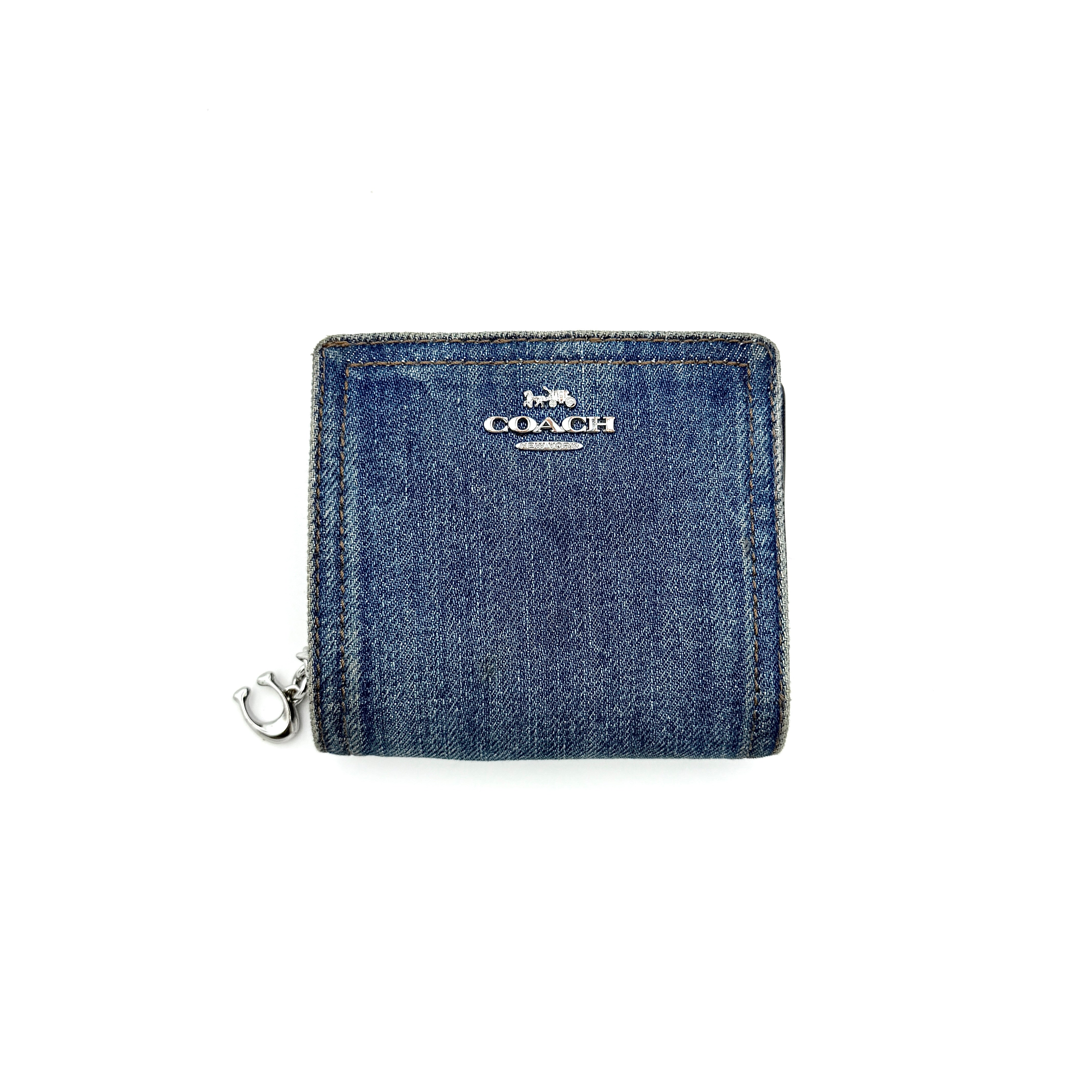 Coach Signature Snap Wallet in blue denim with silver-tone logo, shown closed from the front.