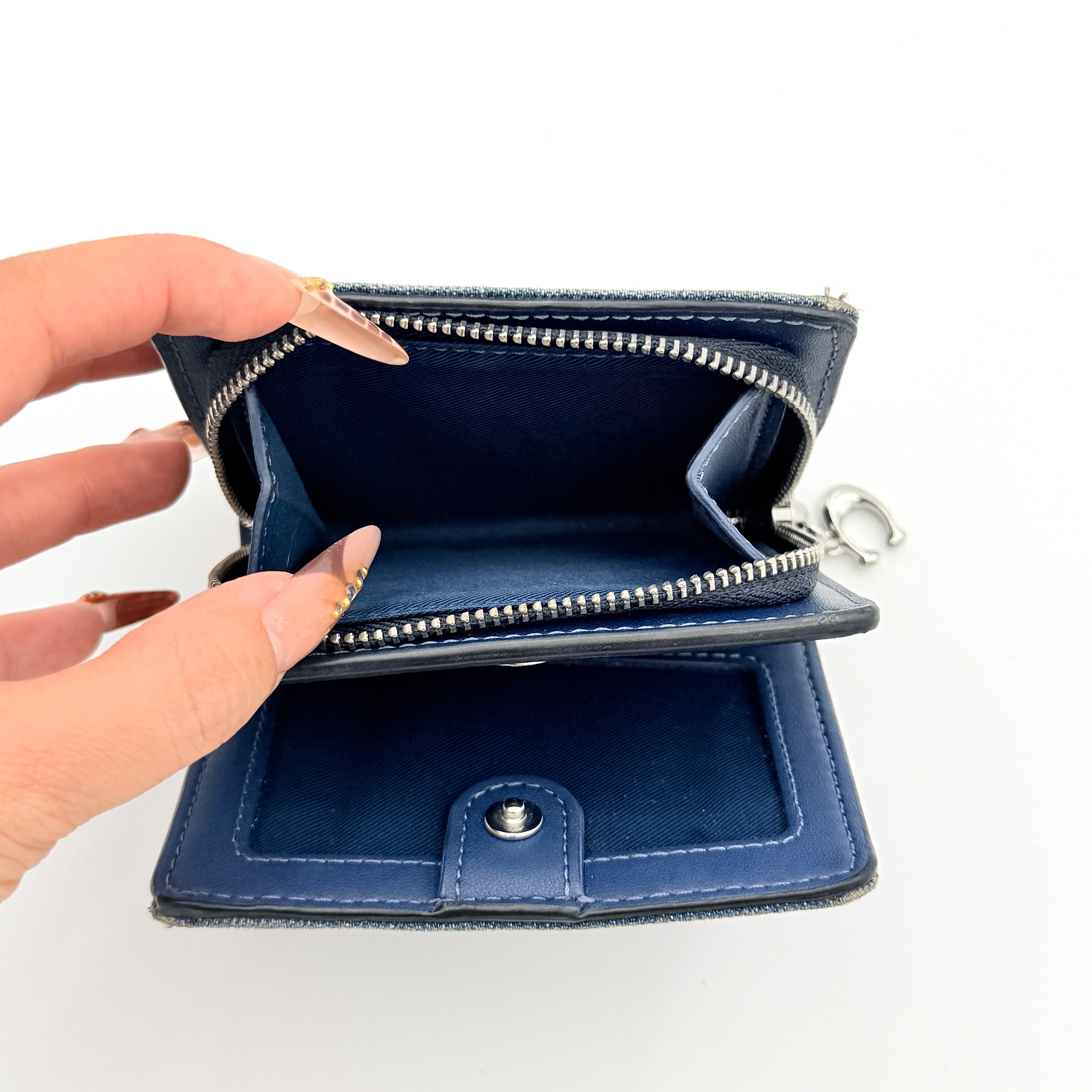 Coach Signature Snap Wallet in blue denim with silver-tone logo, shown closed from the front.