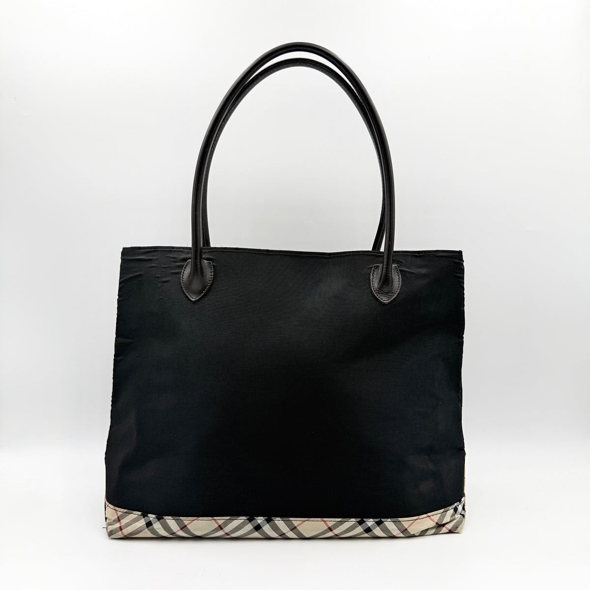 Burberry Blue Label black nylon tote bag with leather handles and nova check trim at the base.