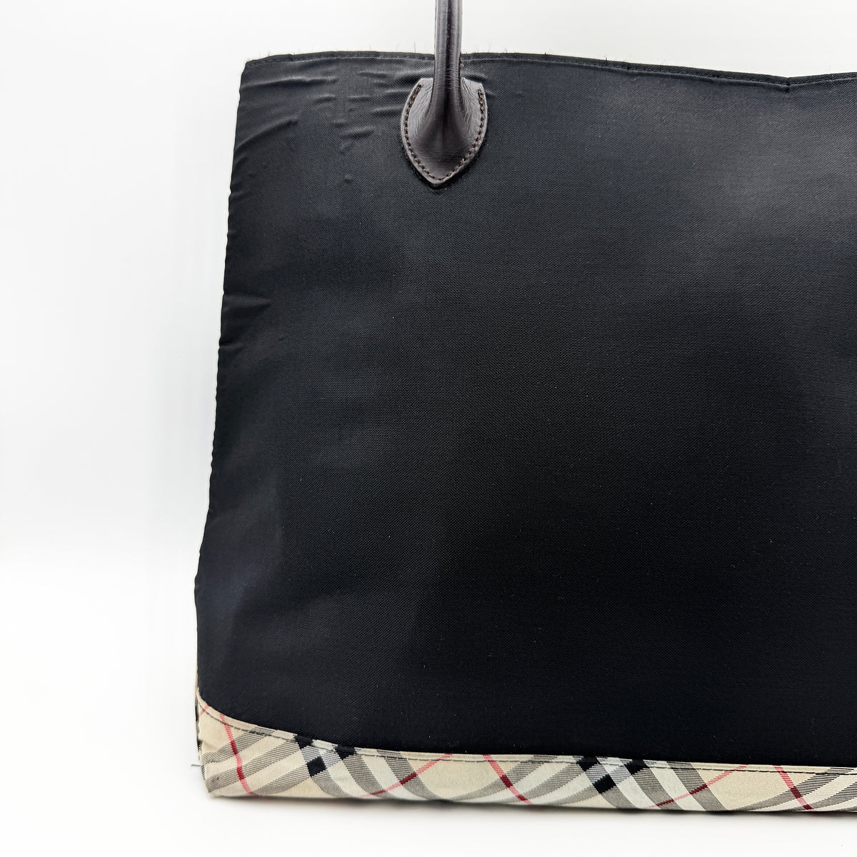Burberry Blue Label black nylon tote bag with leather handles and nova check trim at the base.