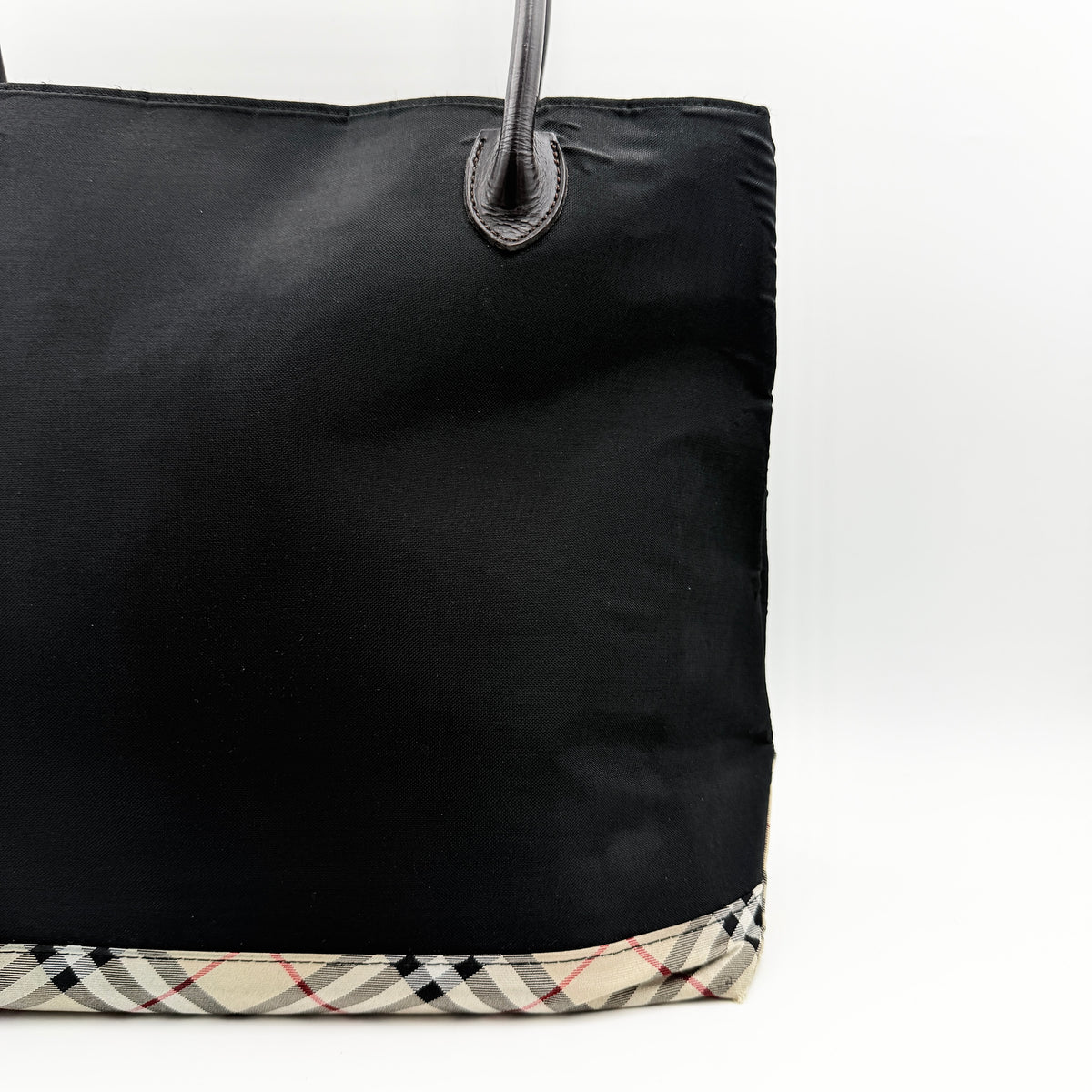 Burberry Blue Label black nylon tote bag with leather handles and nova check trim at the base.