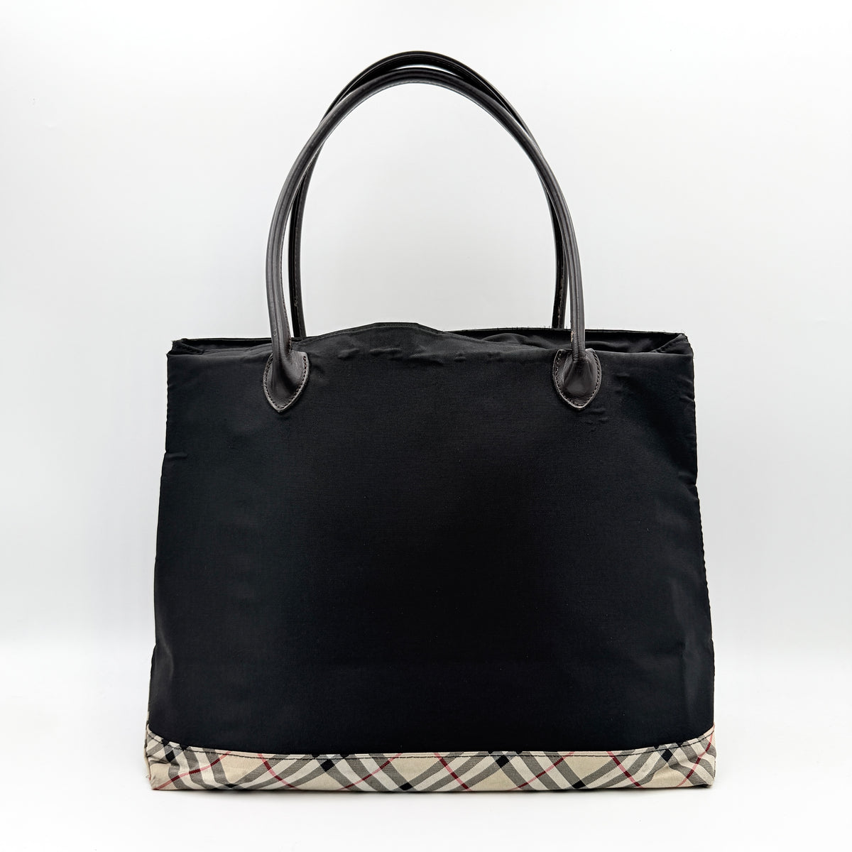Burberry Blue Label black nylon tote bag with leather handles and nova check trim at the base.