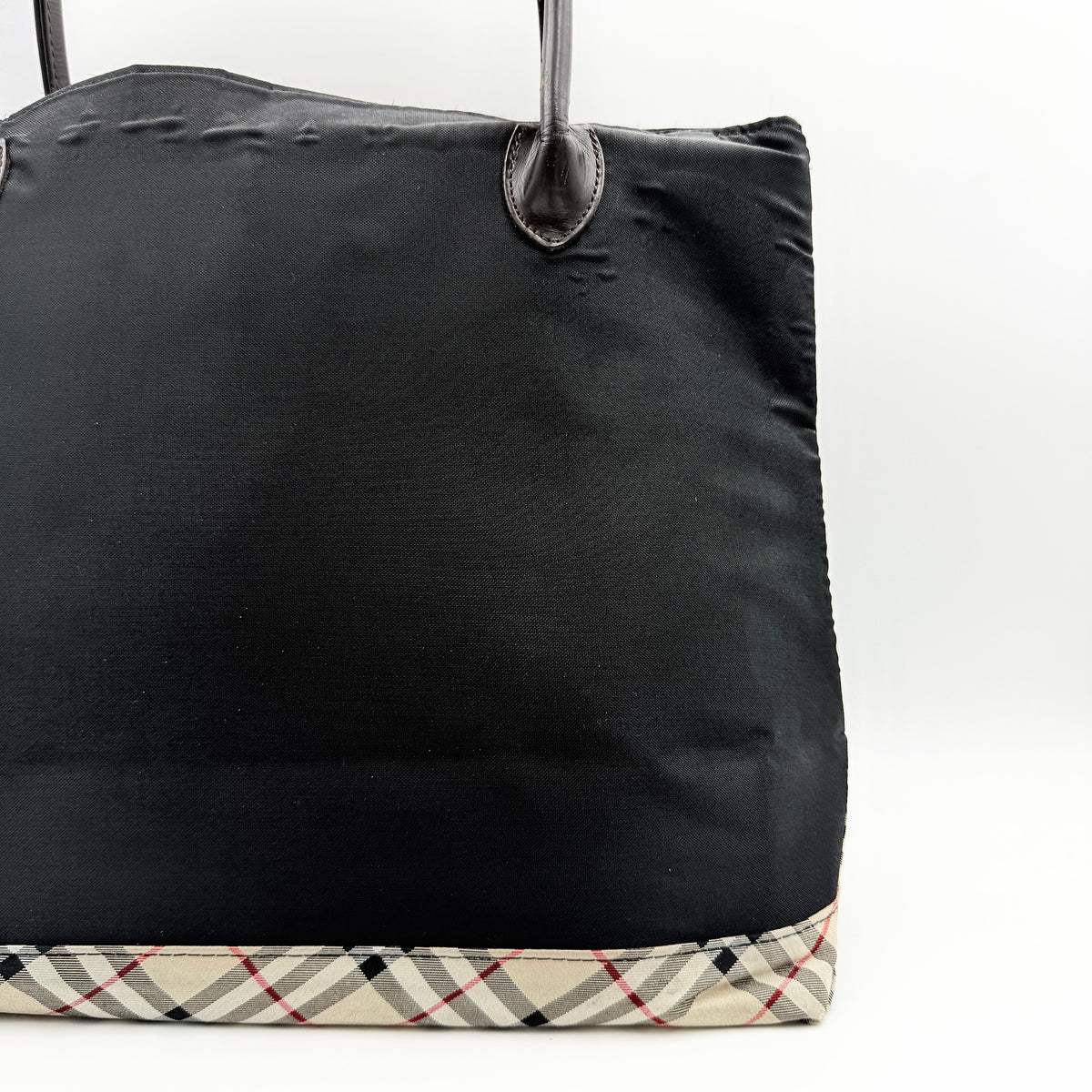 Burberry Blue Label black nylon tote bag with leather handles and nova check trim at the base.