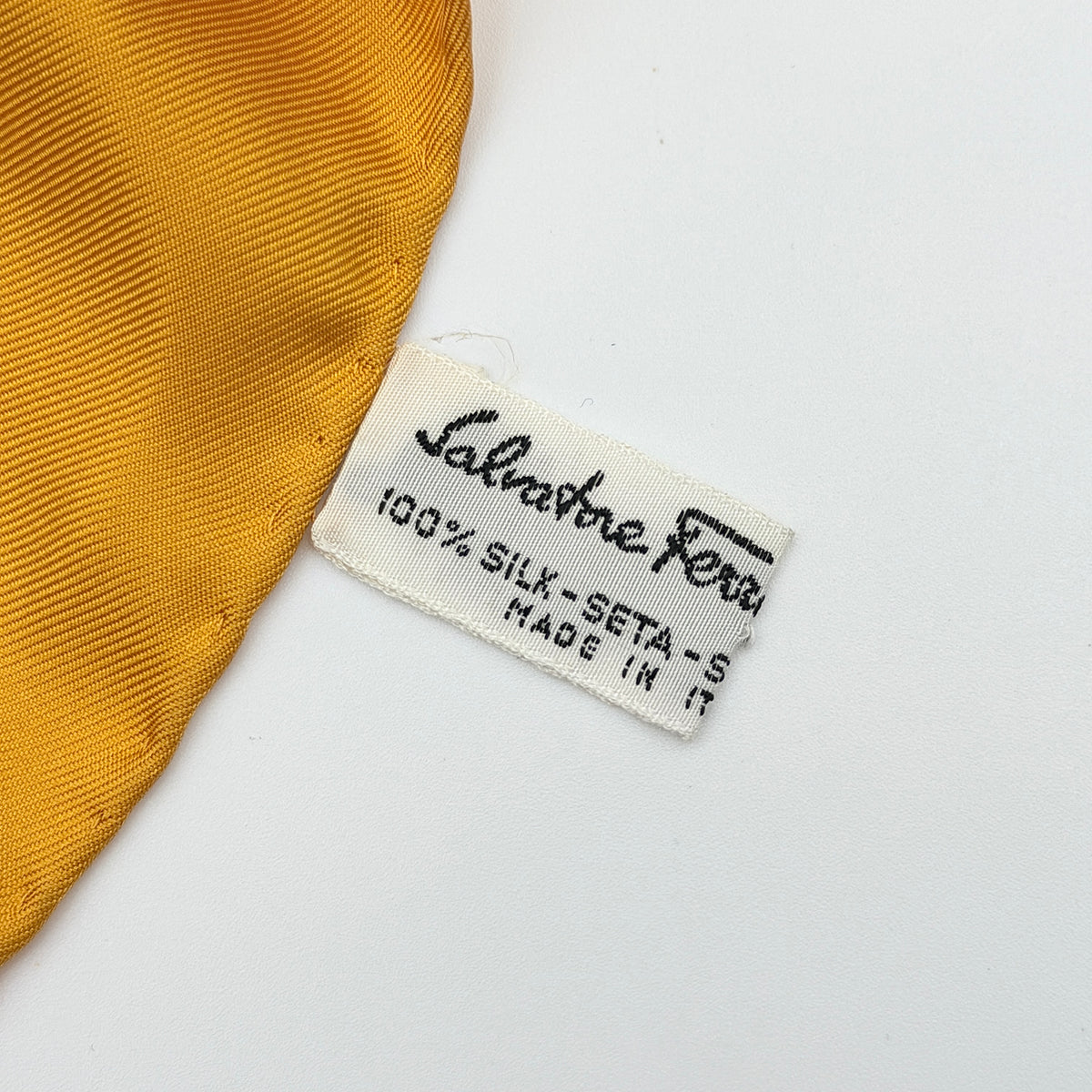 Salvatore Ferragamo silk scarf in gold and black with detailed lion and jungle botanical print.