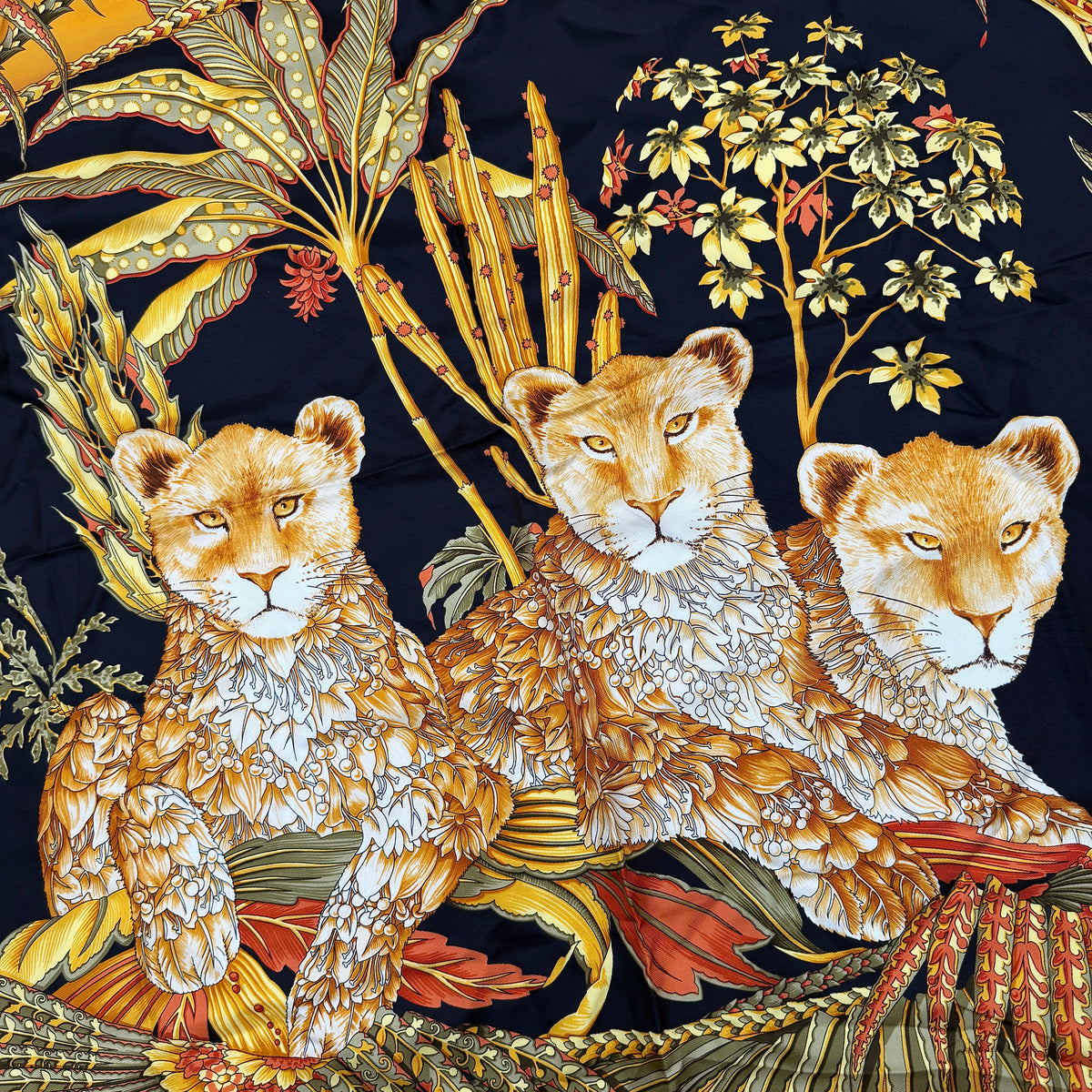 Salvatore Ferragamo silk scarf in gold and black with detailed lion and jungle botanical print.