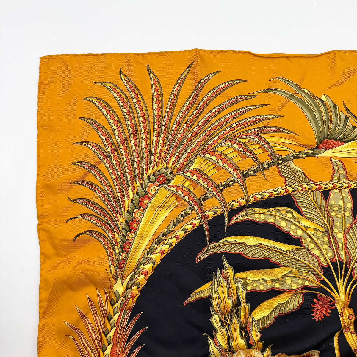 Salvatore Ferragamo silk scarf in gold and black with detailed lion and jungle botanical print.