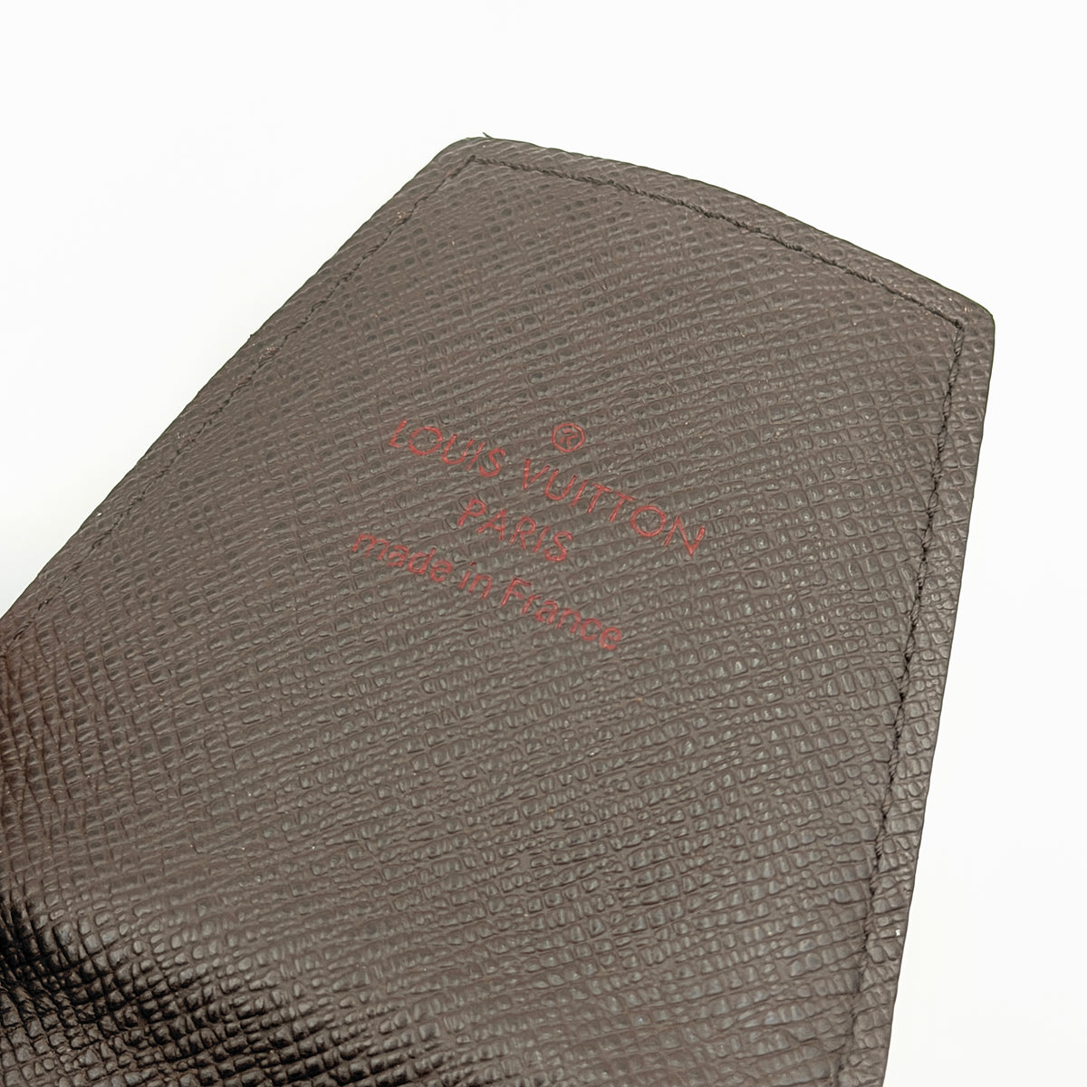 Louis Vuitton Damier brown cigarette case in checked coated canvas with a flap closure, photographed against a white background.