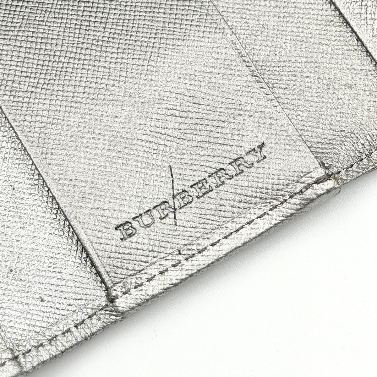 Burberry Nova Check key case in metallic silver leather and beige check canvas with key ring and snap closure.