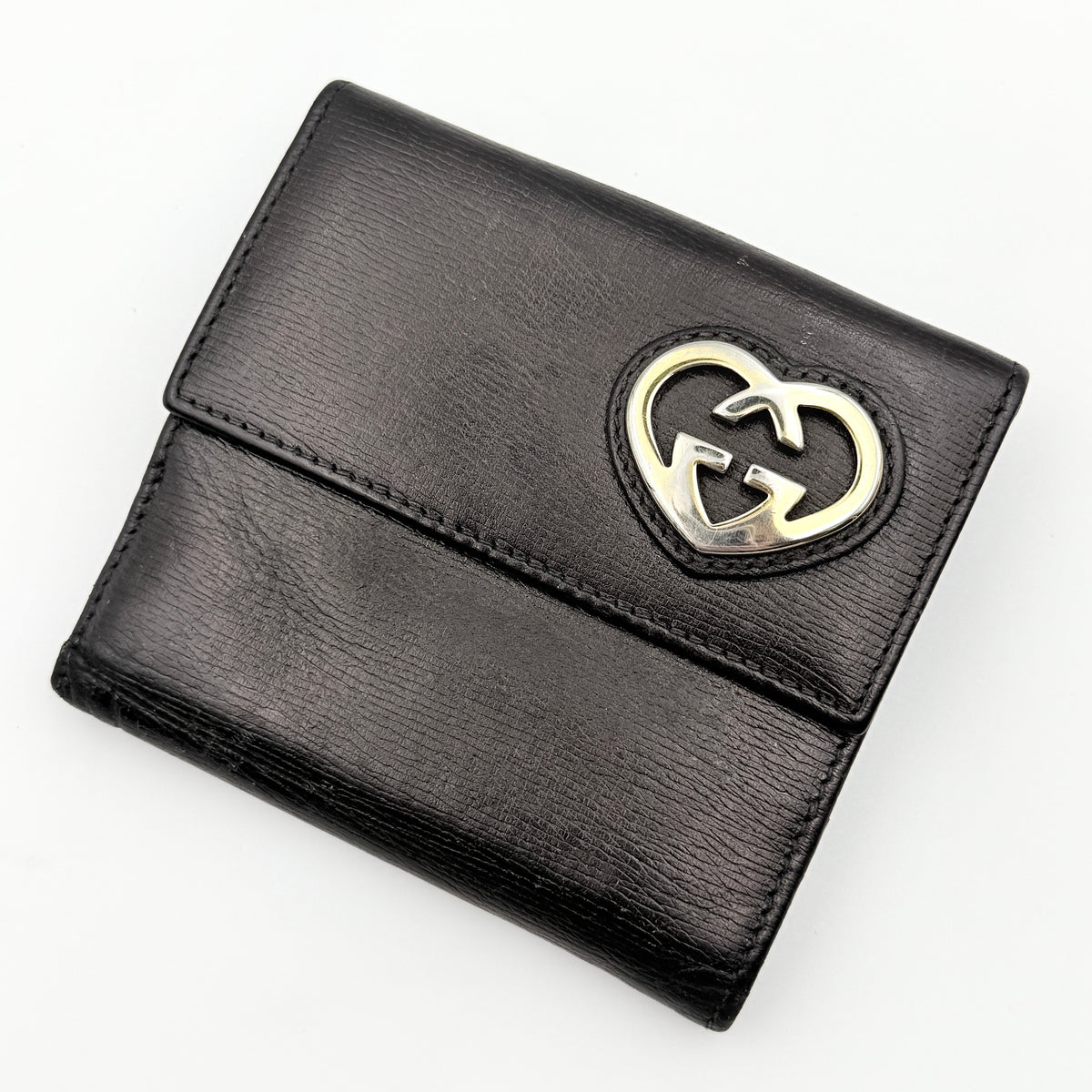 Gucci Interlocking G Heart Bifold Wallet in black leather with iconic silver-tone heart logo on the front flap.