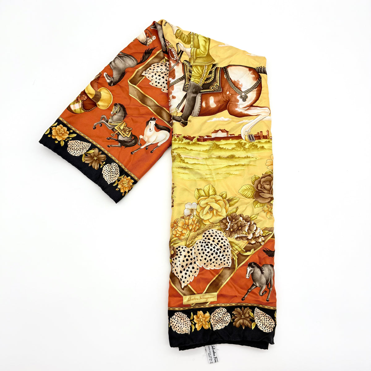 Salvatore Ferragamo silk scarf with a detailed equestrian and floral print in yellow, orange, and black tones.