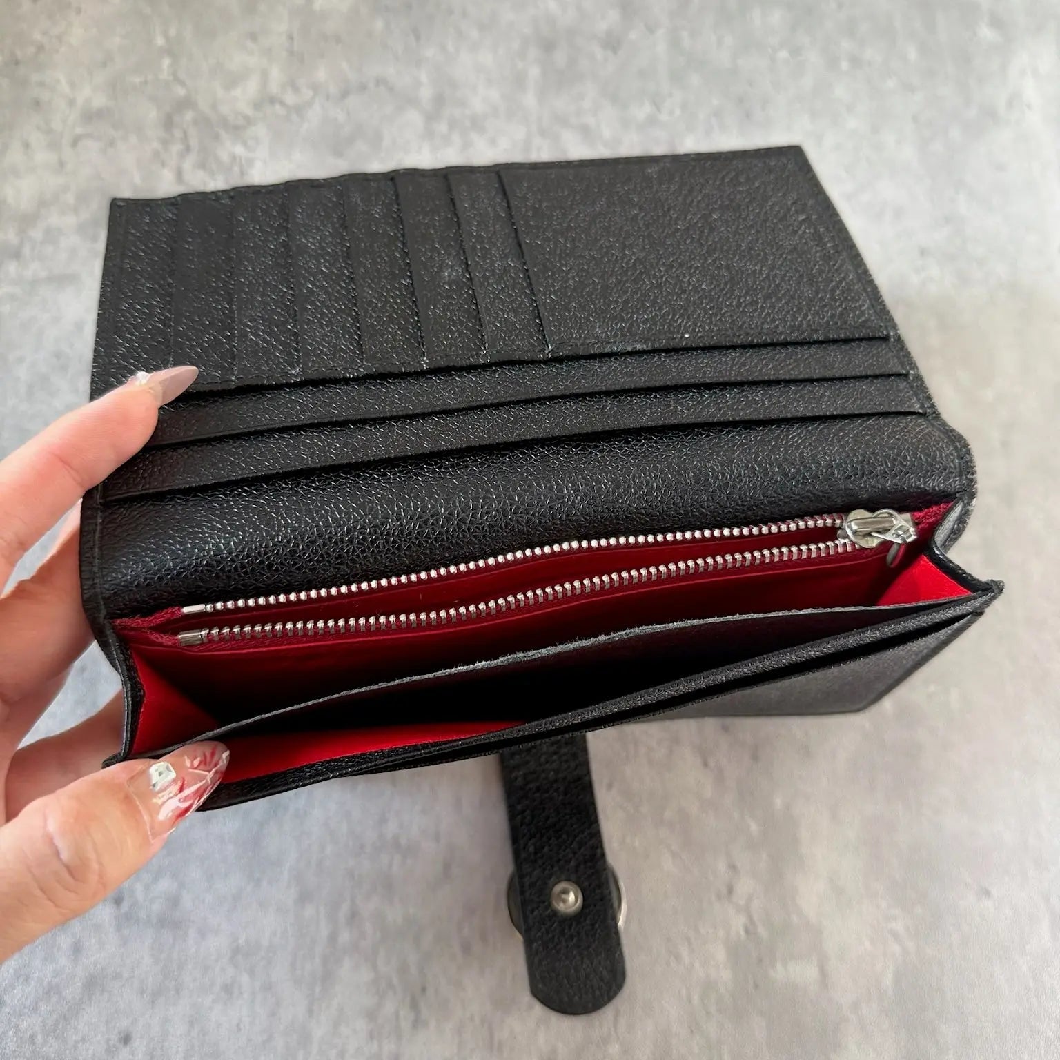 Bvlgari Black Leather Signature Ring Fold Long Wallet with a logo ring closure and red interior.