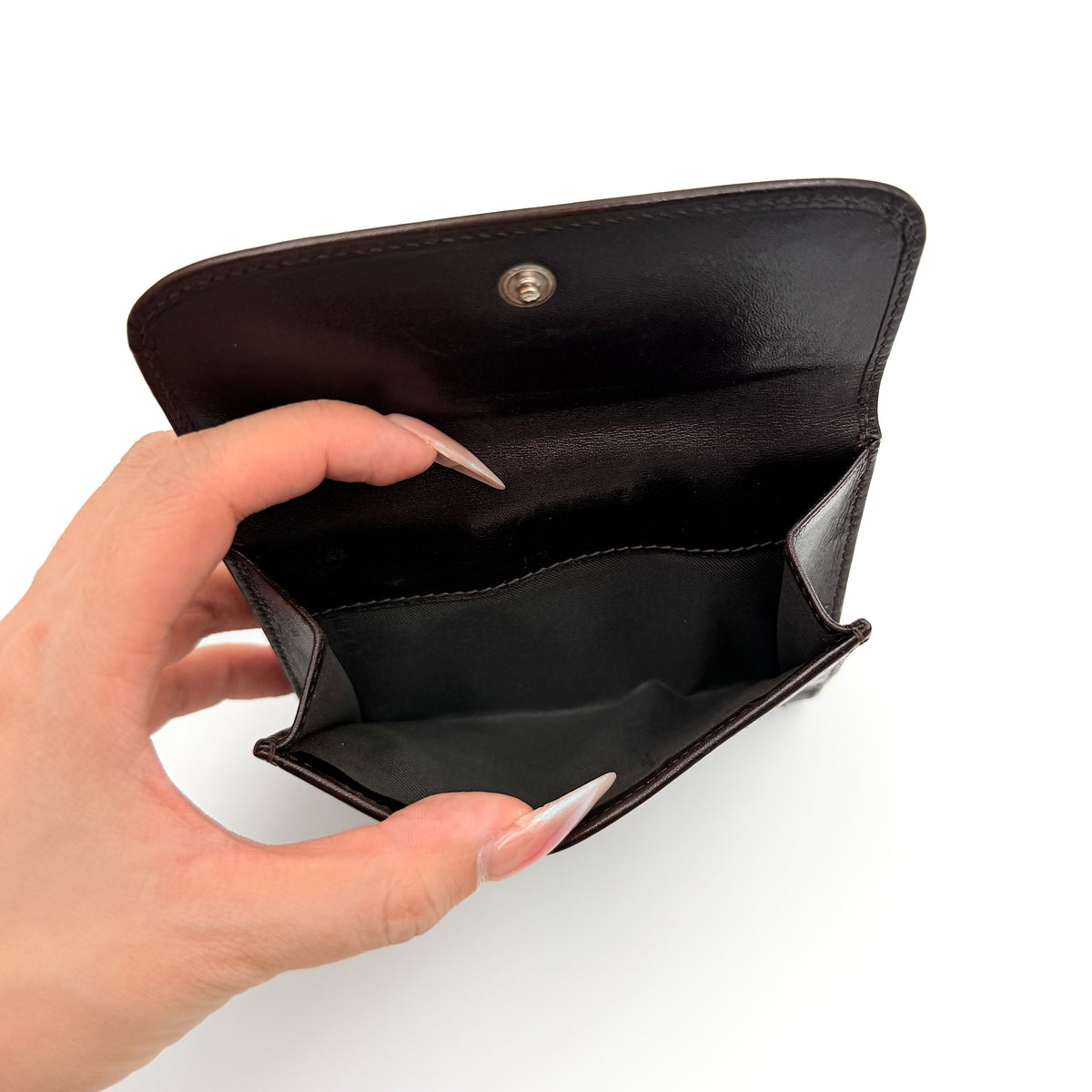 Fendi FF Zucca Monogram bifold wallet in brown and black leather with snap closure, photographed on a white background.
