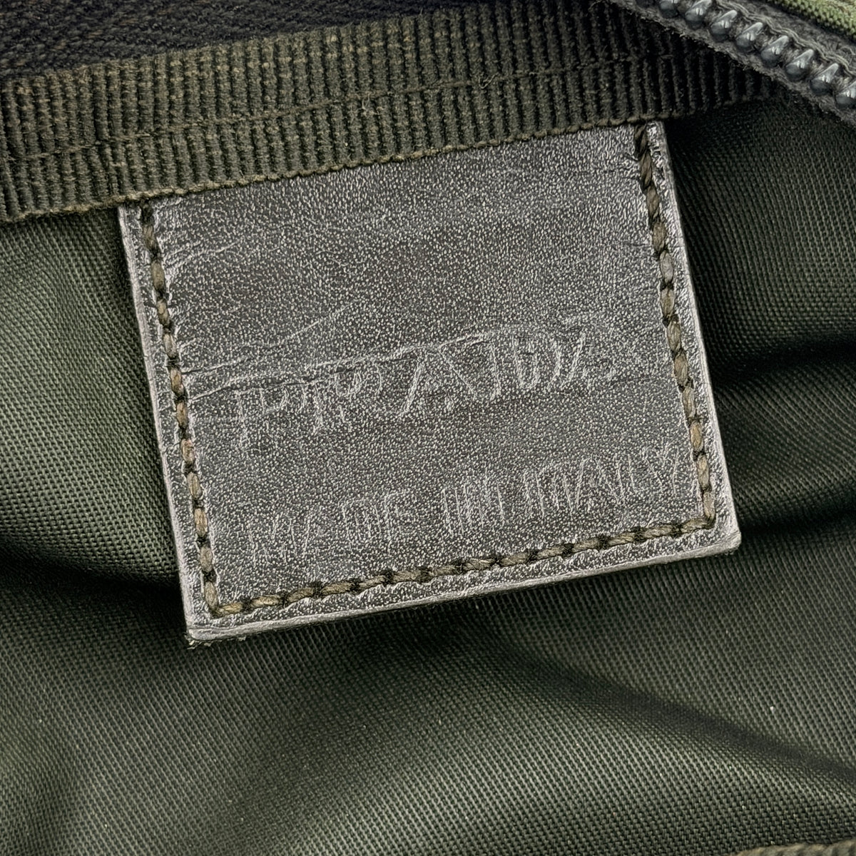 Prada Nylon Utility Pouch in dark green with silver triangle logo and zip closure.