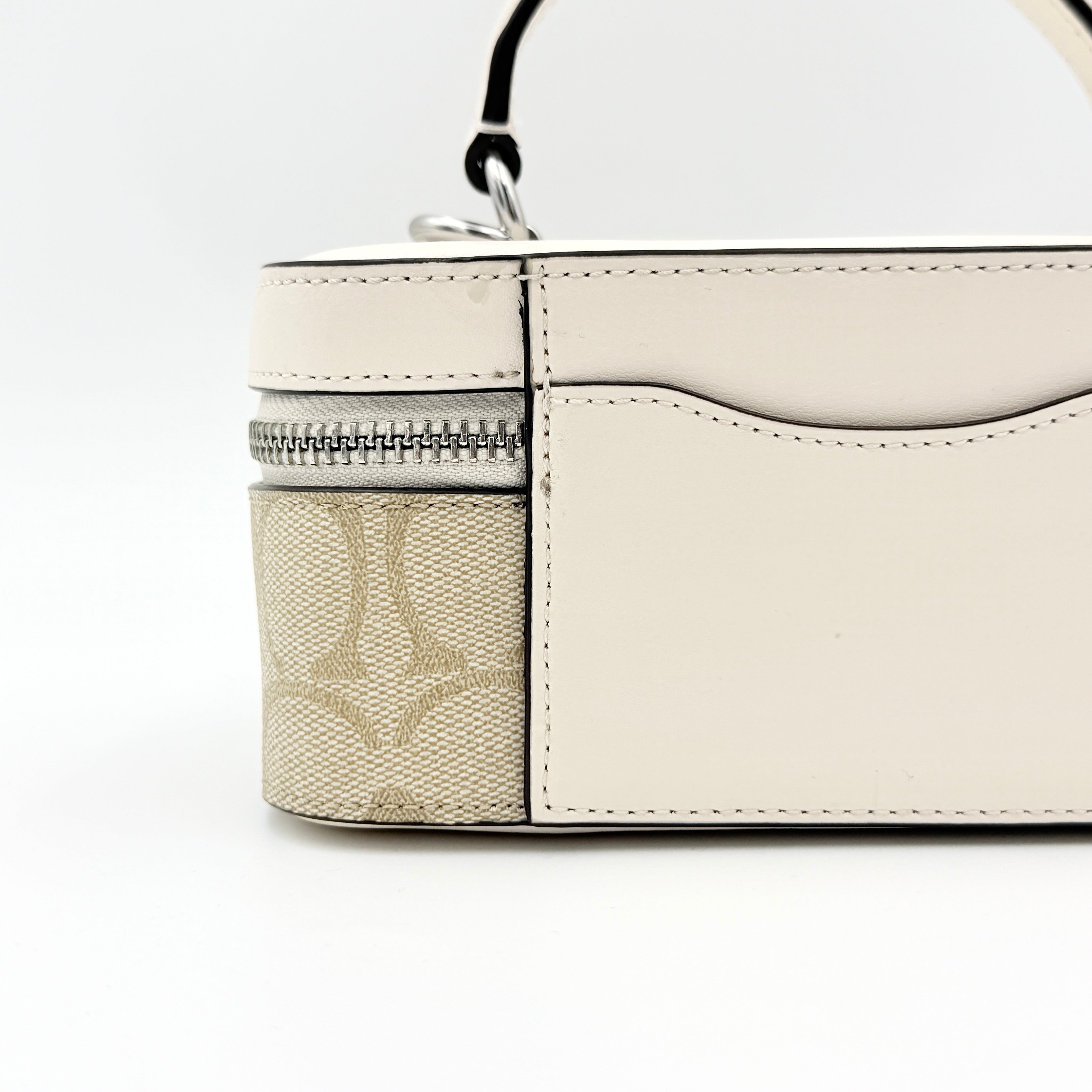 Coach 2Way Signature Train Case in beige and white canvas with a leather top handle and detachable strap, shown with silver zip hardware.