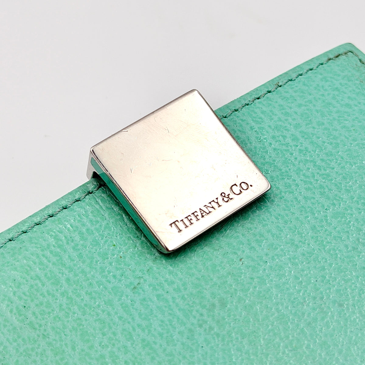 Tiffany & Co. bifold compact wallet in Tiffany Blue leather with silver-tone clasp, photographed on a clean white background.