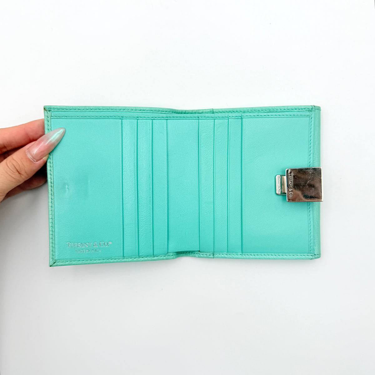 Tiffany & Co. bifold compact wallet in Tiffany Blue leather with silver-tone clasp, photographed on a clean white background.