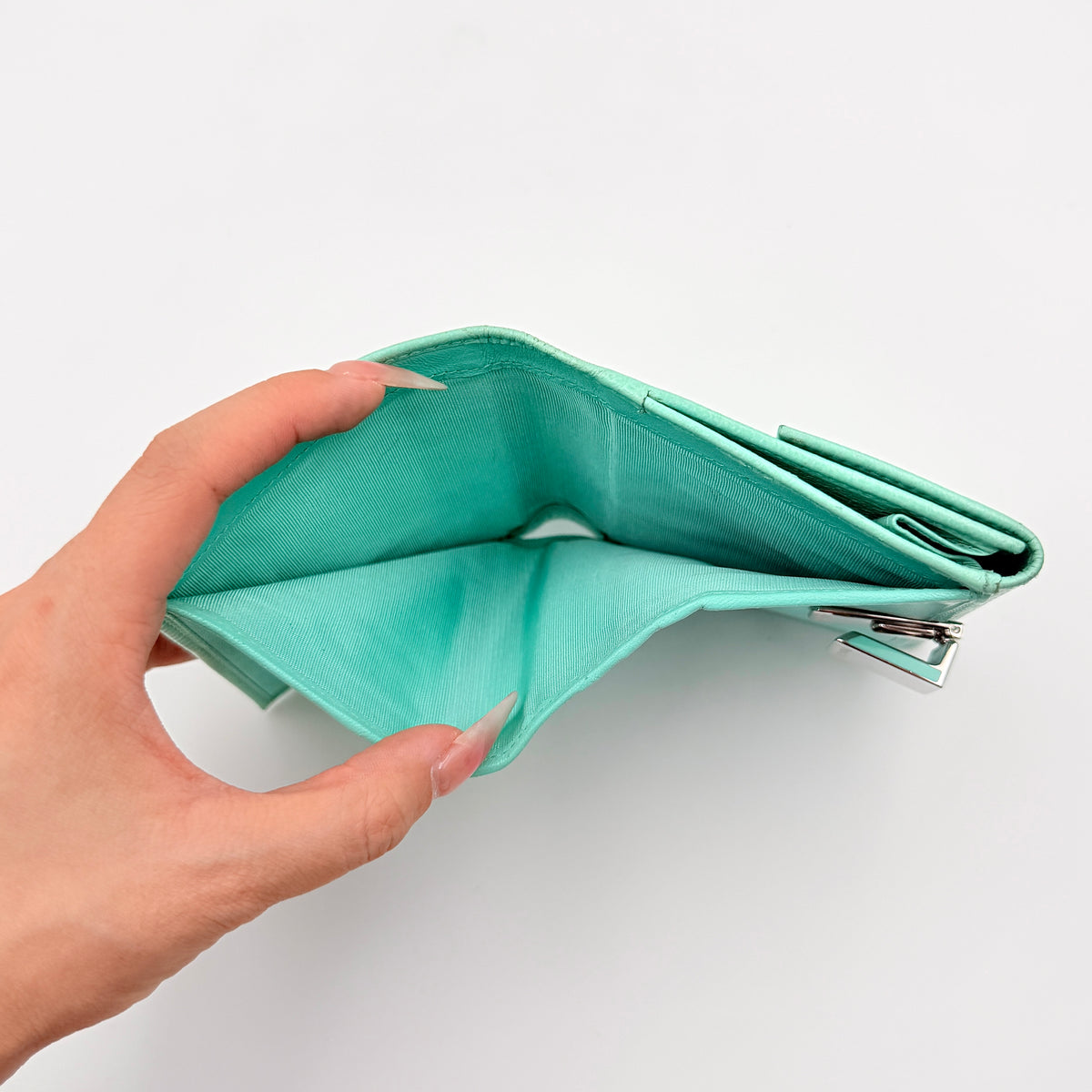 Tiffany & Co. bifold compact wallet in Tiffany Blue leather with silver-tone clasp, photographed on a clean white background.