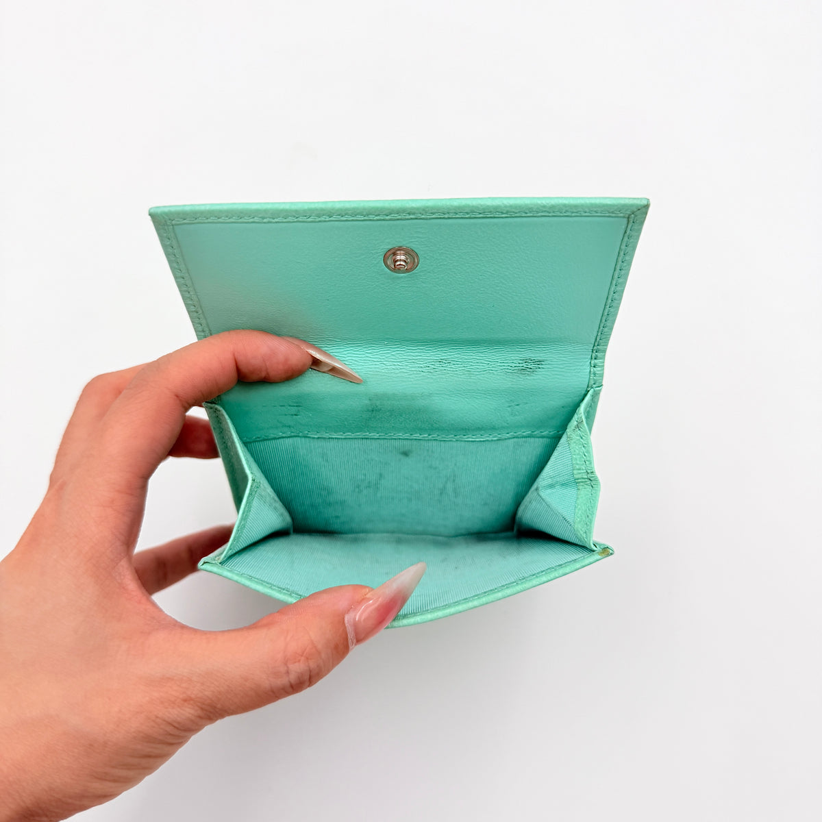 Tiffany & Co. bifold compact wallet in Tiffany Blue leather with silver-tone clasp, photographed on a clean white background.