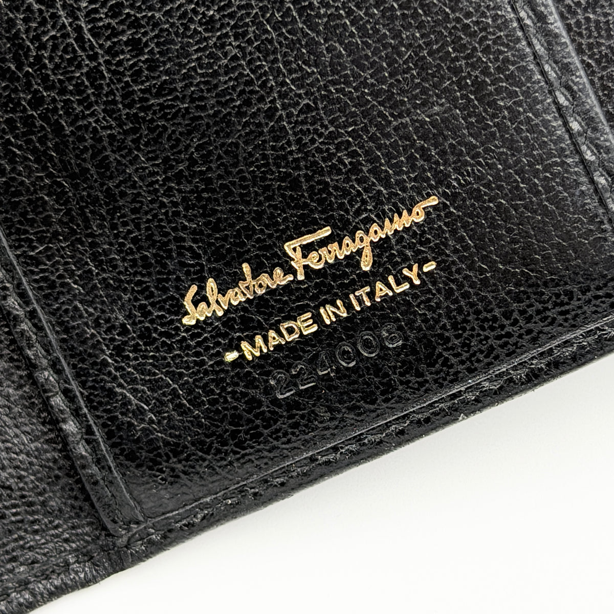 Salvatore Ferragamo Gancini Continental Wallet in black leather with gold-tone Gancini clasp, photographed closed on a white background.