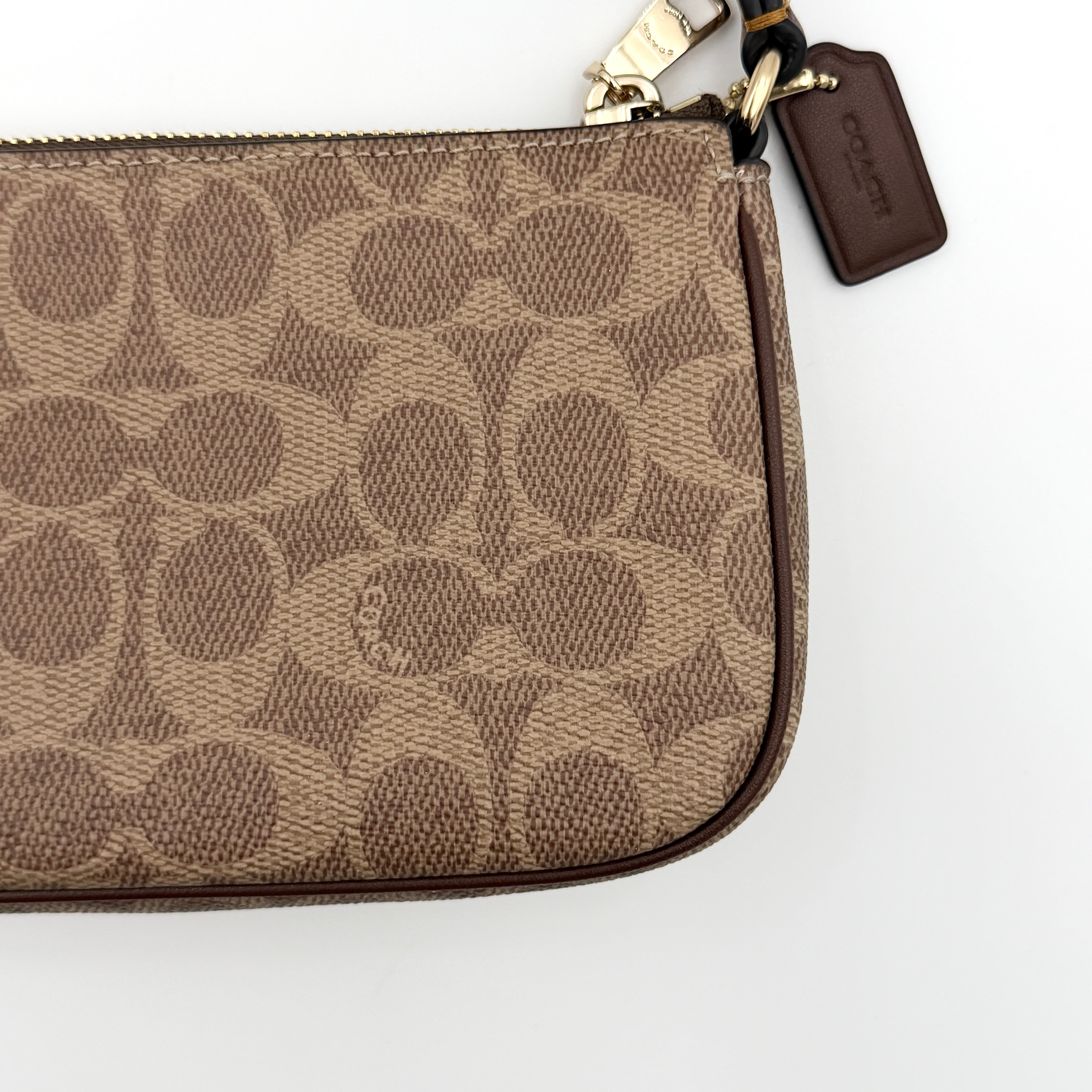 Coach Signature Nolita 19 Shoulder Bag in beige and brown canvas with gold tone hardware and detachable leather strap.