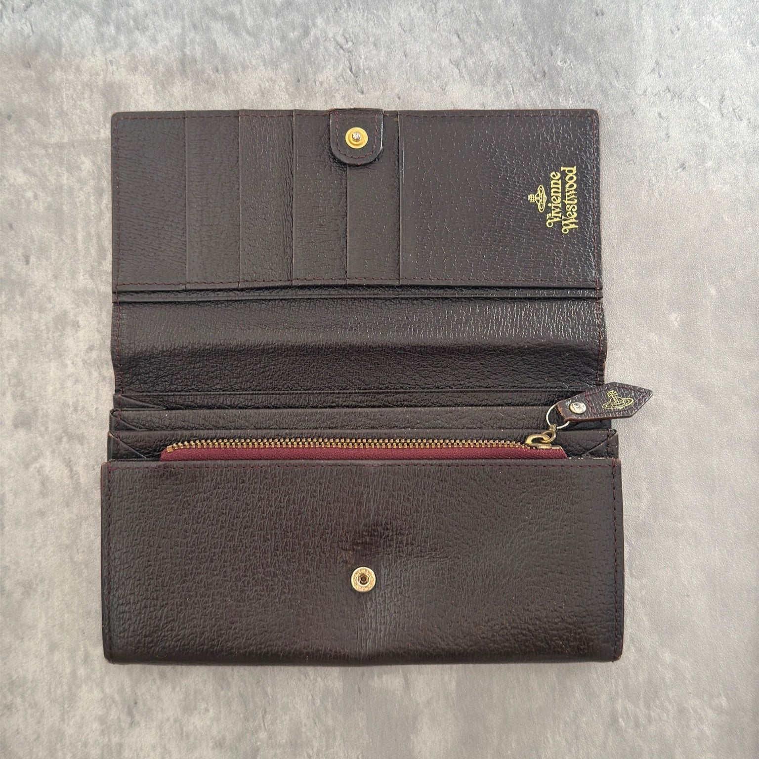 Vivienne Westwood Signature Orb Bi-fold Long Wallet in Black Leather with Gold-Tone Hardware and Multiple Interior Compartments.