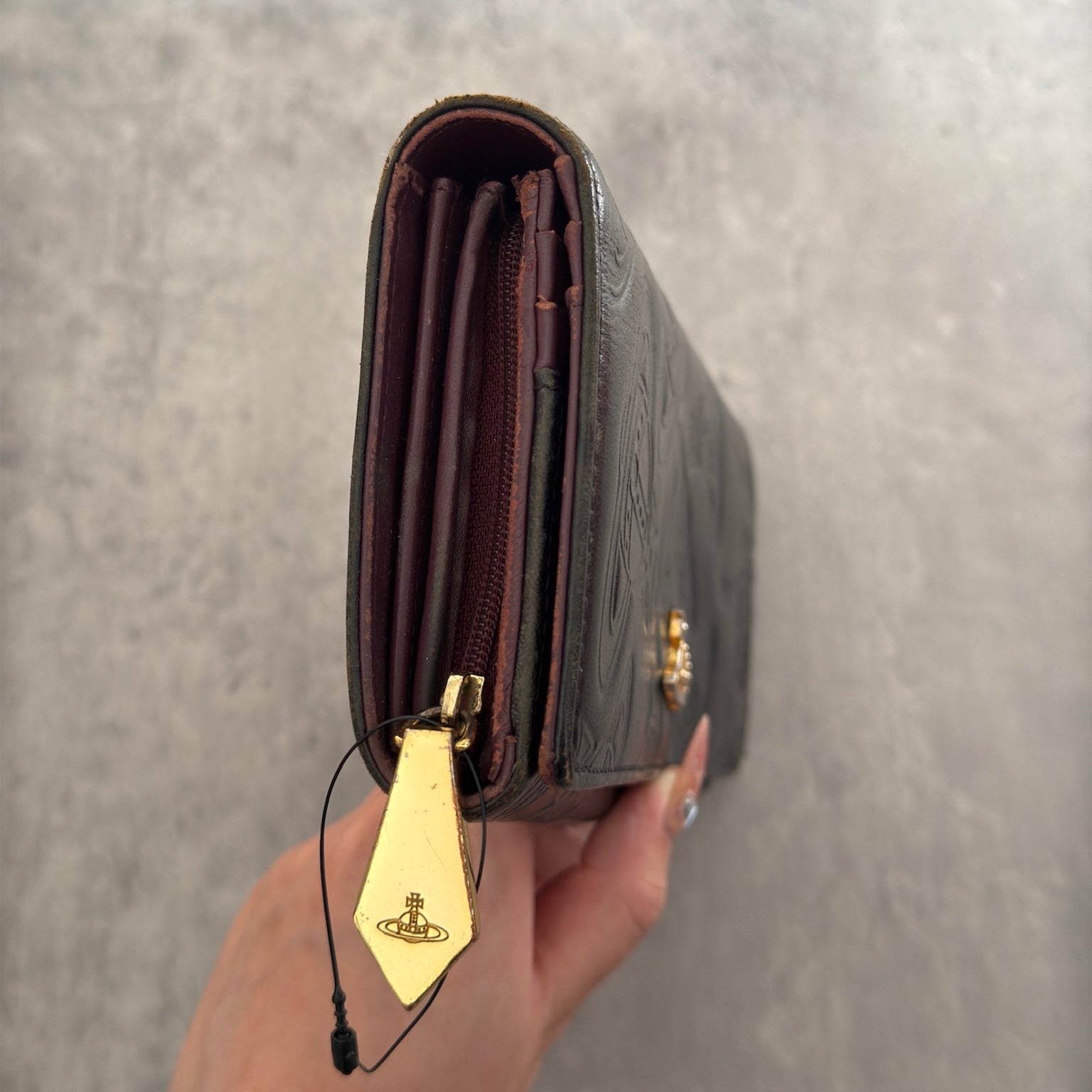 Vivienne Westwood Dancing Orb long wallet in black with iconic orb embossing, featuring a structured interior and clip closure, represents bold, punk-inspired luxury.