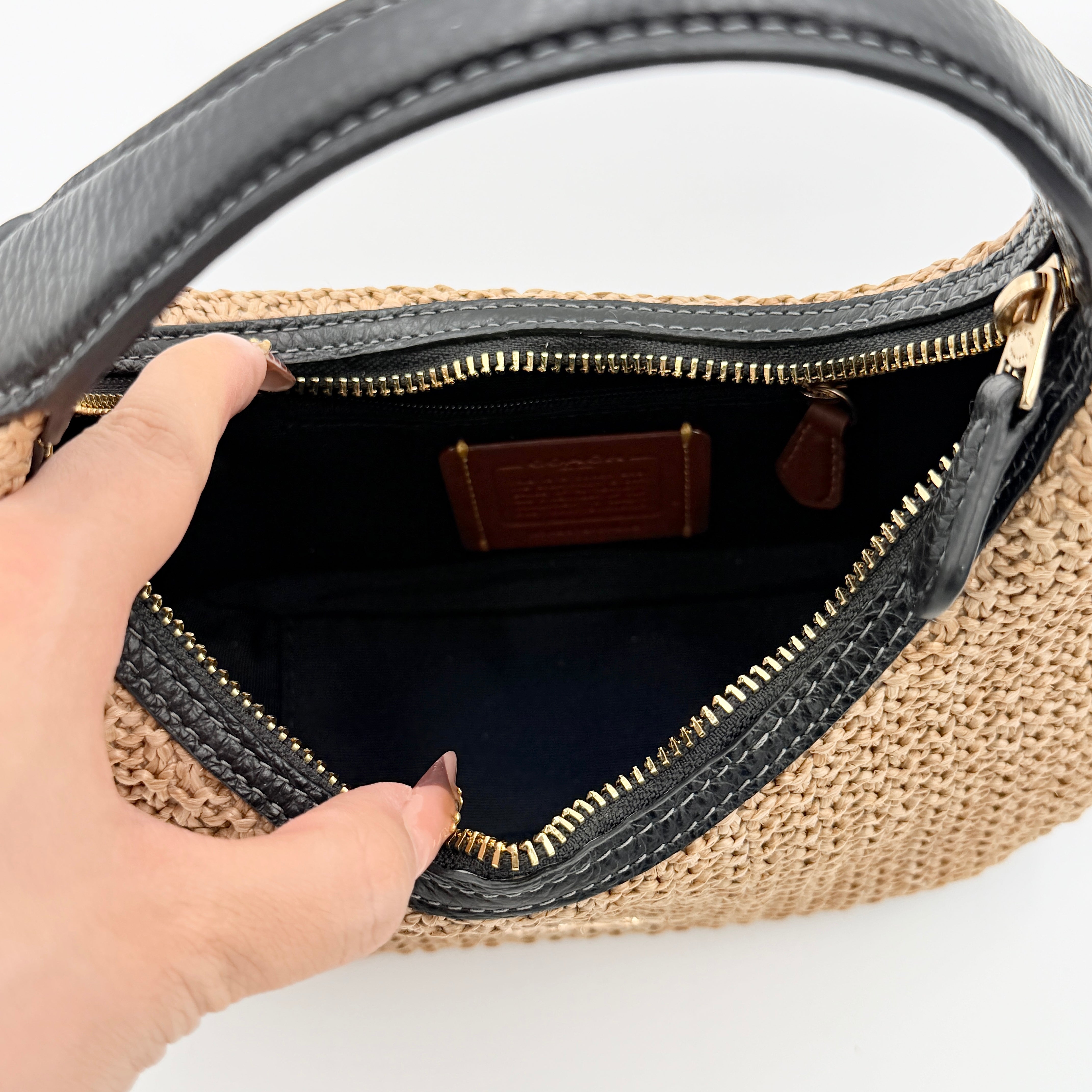 Coach Carmen Mini 2Way Shoulder Bag in beige and black with textured woven body, leather trim, and gold-tone hardware.
