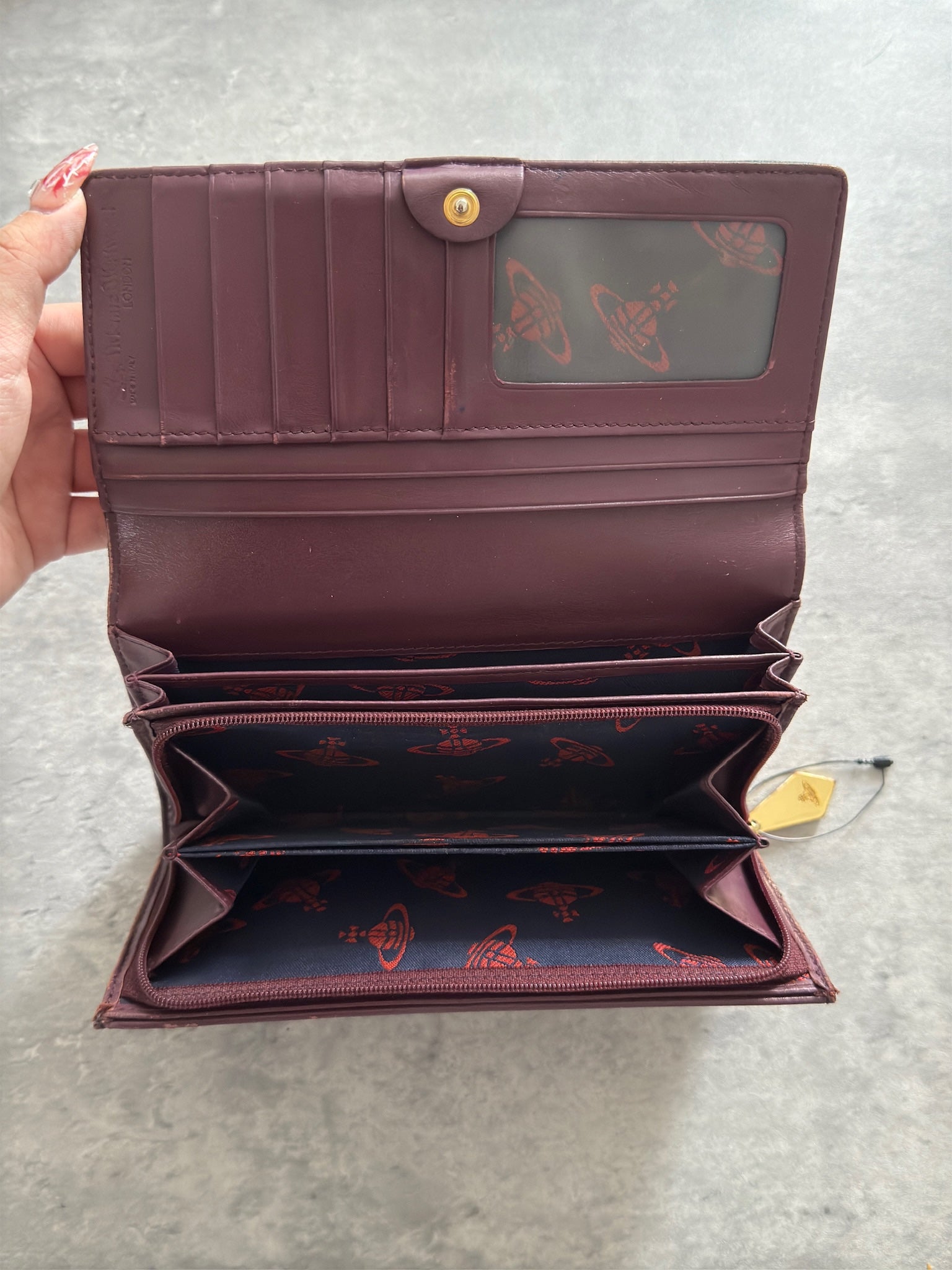 Vivienne Westwood Dancing Orb long wallet in black with iconic orb embossing, featuring a structured interior and clip closure, represents bold, punk-inspired luxury.