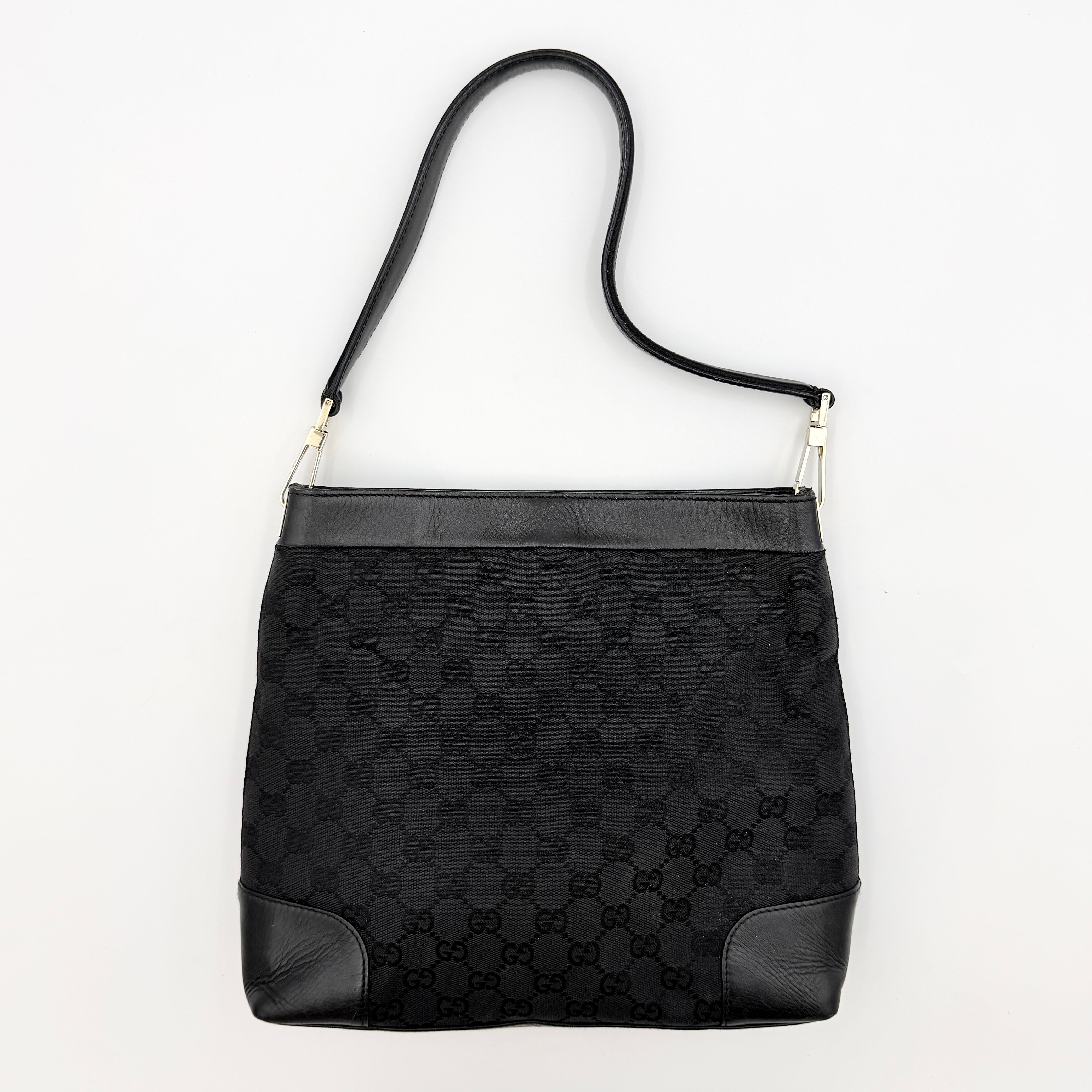 Gucci GG Monogram Bucket Shoulder Bag in black canvas and leather with silver-tone hardware, shown on a white background.