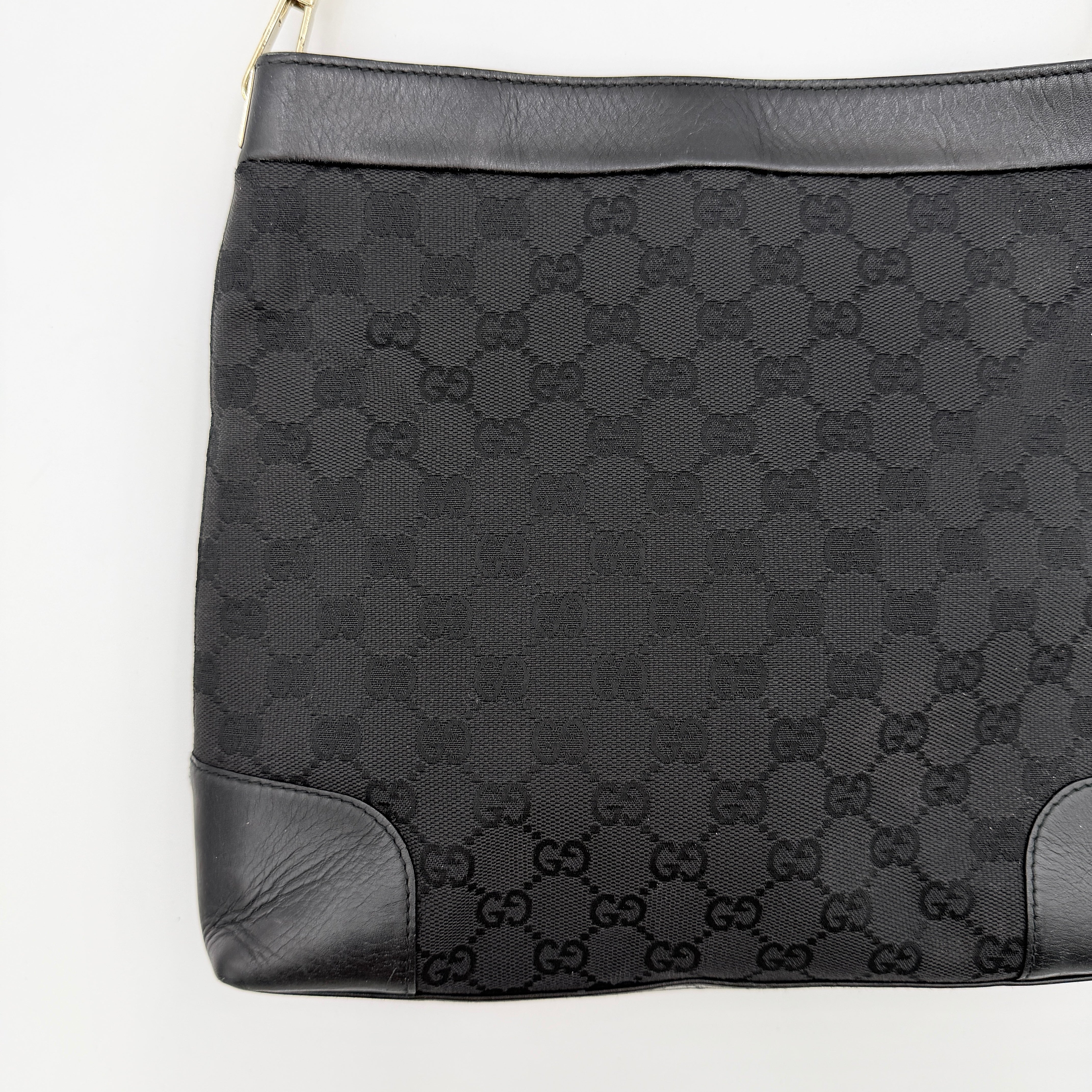 Gucci GG Monogram Bucket Shoulder Bag in black canvas and leather with silver-tone hardware, shown on a white background.