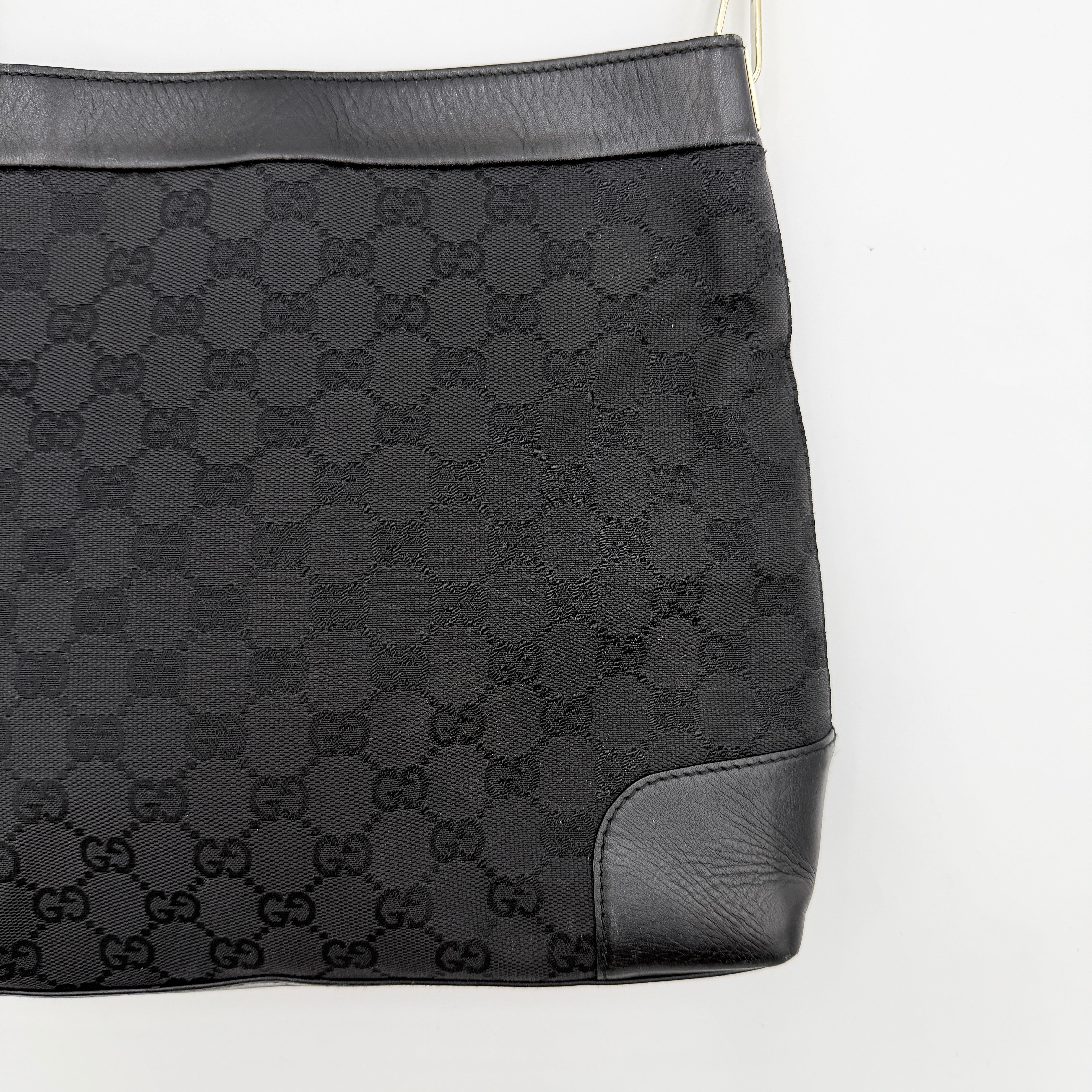 Gucci GG Monogram Bucket Shoulder Bag in black canvas and leather with silver-tone hardware, shown on a white background.