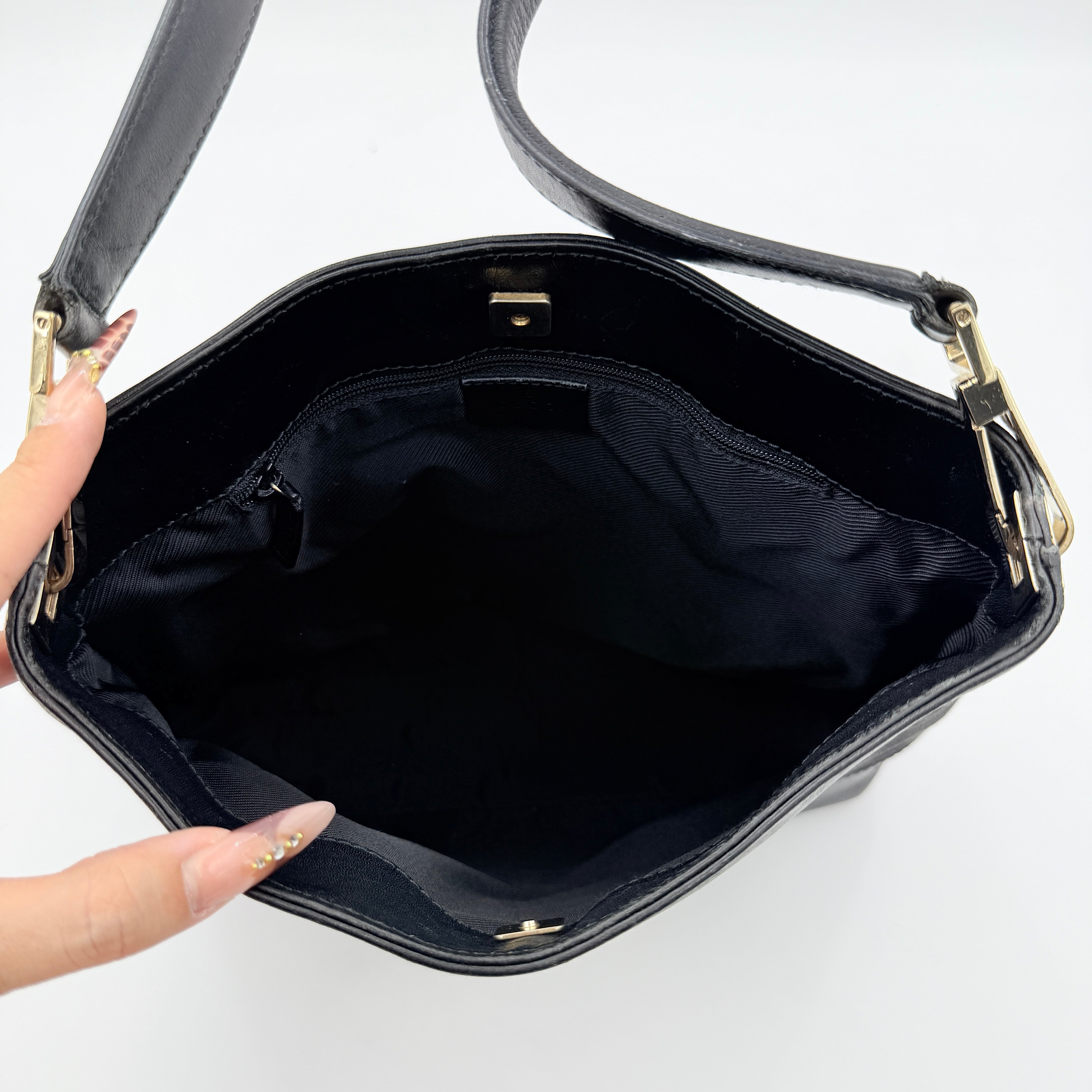 Gucci GG Monogram Bucket Shoulder Bag in black canvas and leather with silver-tone hardware, shown on a white background.