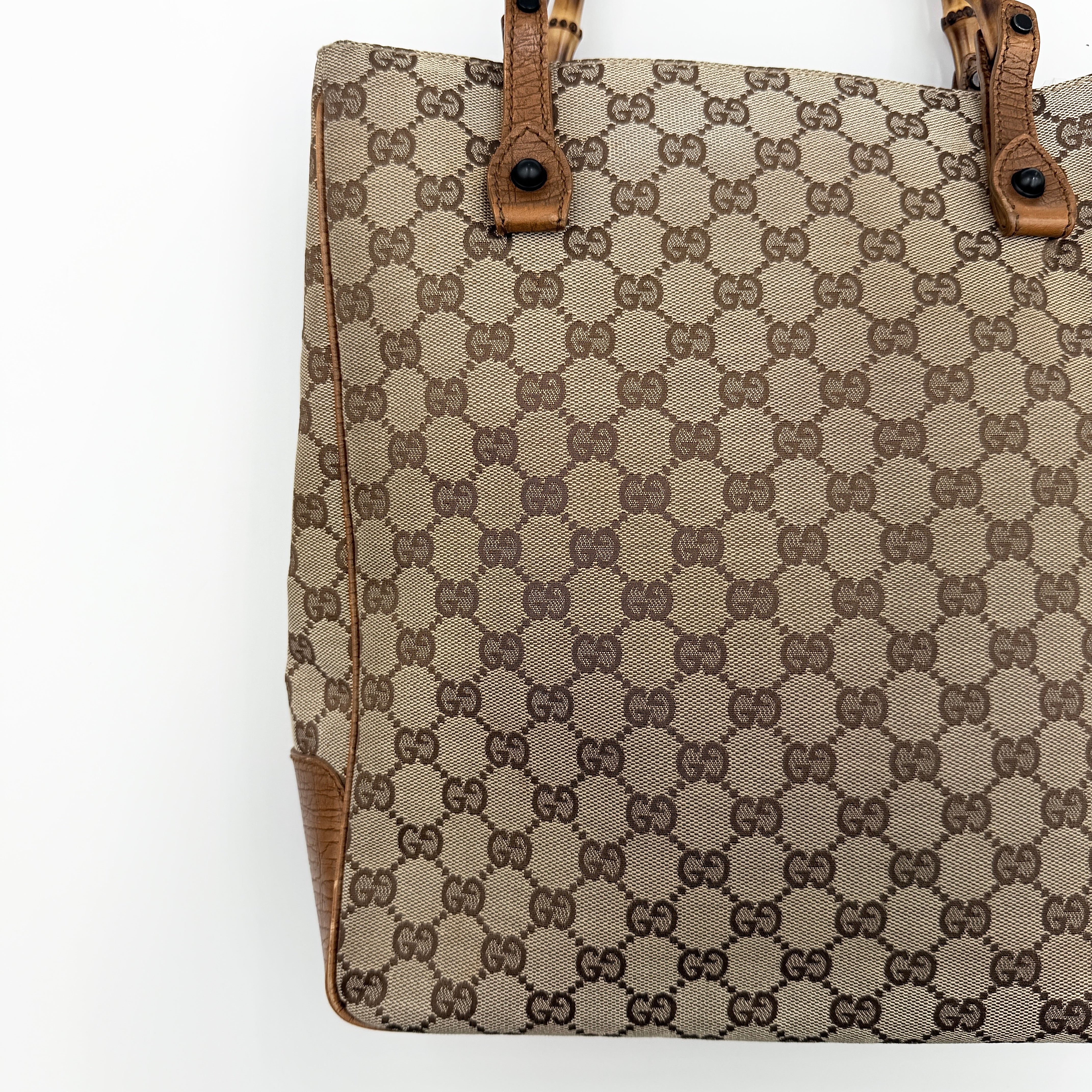 Gucci GG Monogram Bamboo Shoulder Bag in beige and brown canvas with bamboo top handles displayed upright.