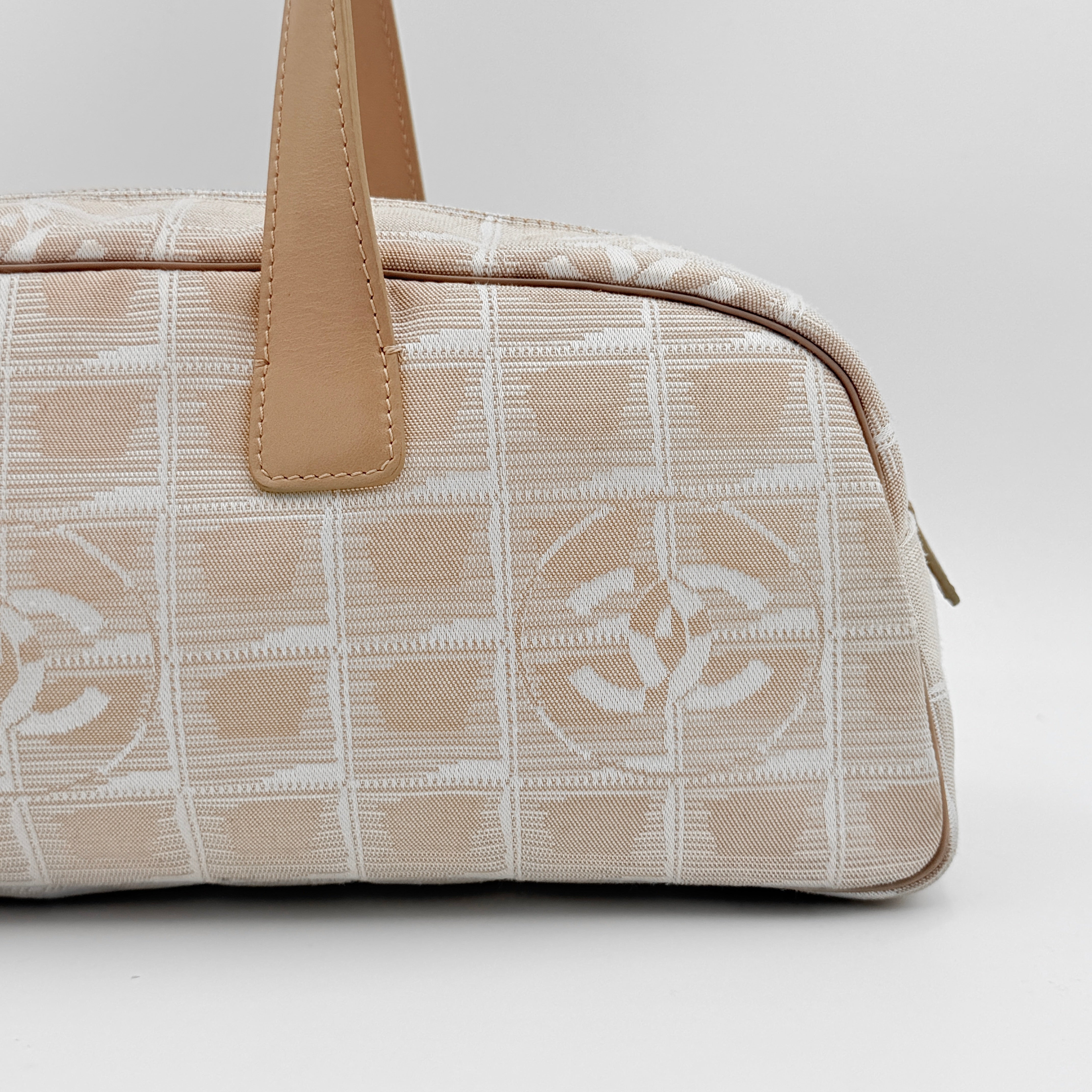 Chanel Travel Mini Boston Bag in beige nylon with CC motif and tan leather handles, shown in front view.