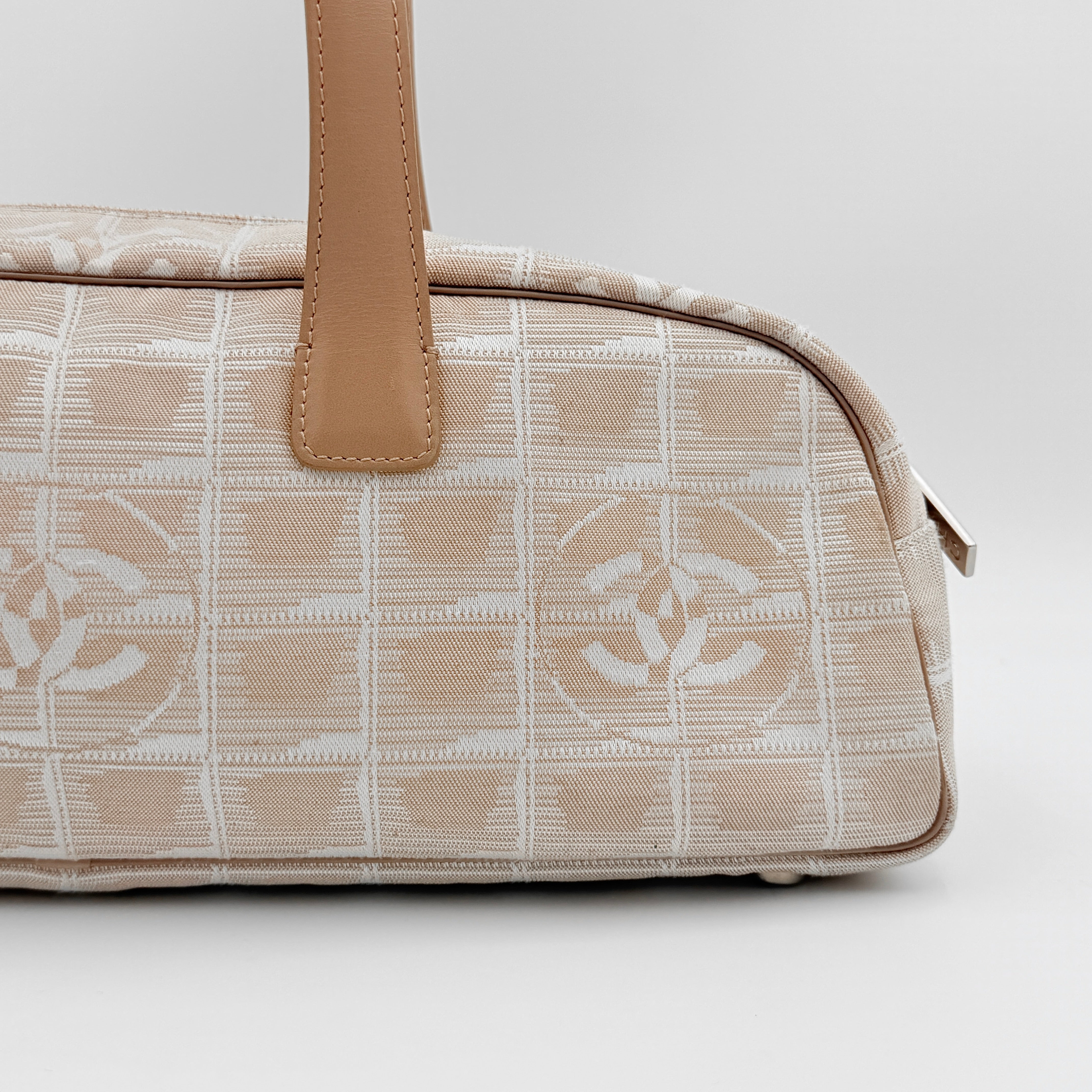 Chanel Travel Mini Boston Bag in beige nylon with CC motif and tan leather handles, shown in front view.
