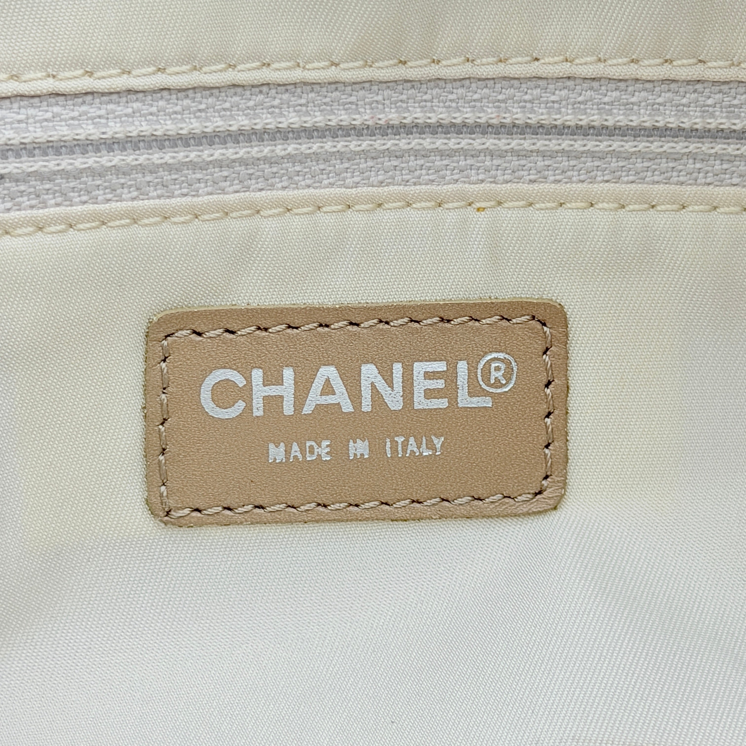 Chanel Travel Mini Boston Bag in beige nylon with CC motif and tan leather handles, shown in front view.