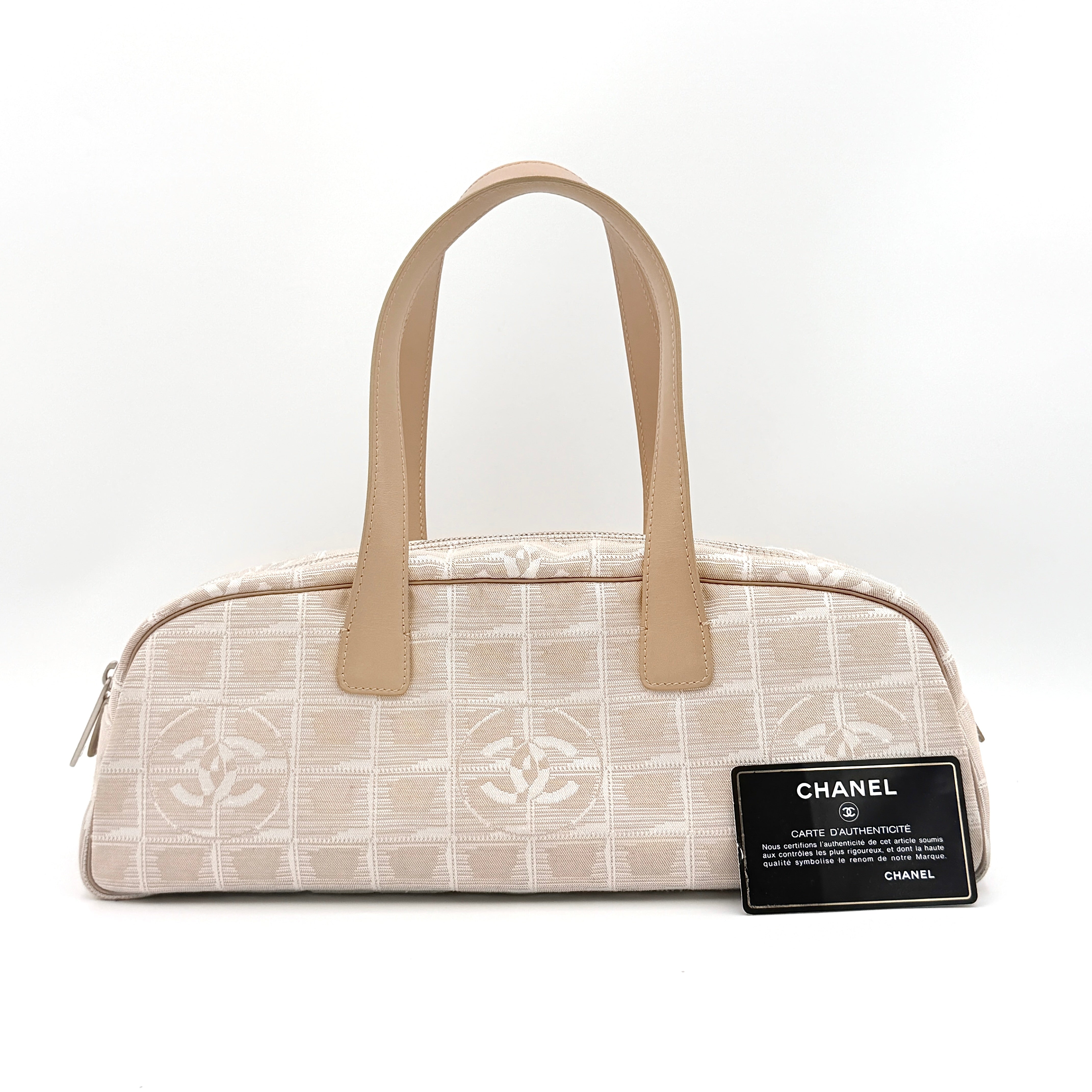Chanel Travel Mini Boston Bag in beige nylon with CC motif and tan leather handles, shown in front view.