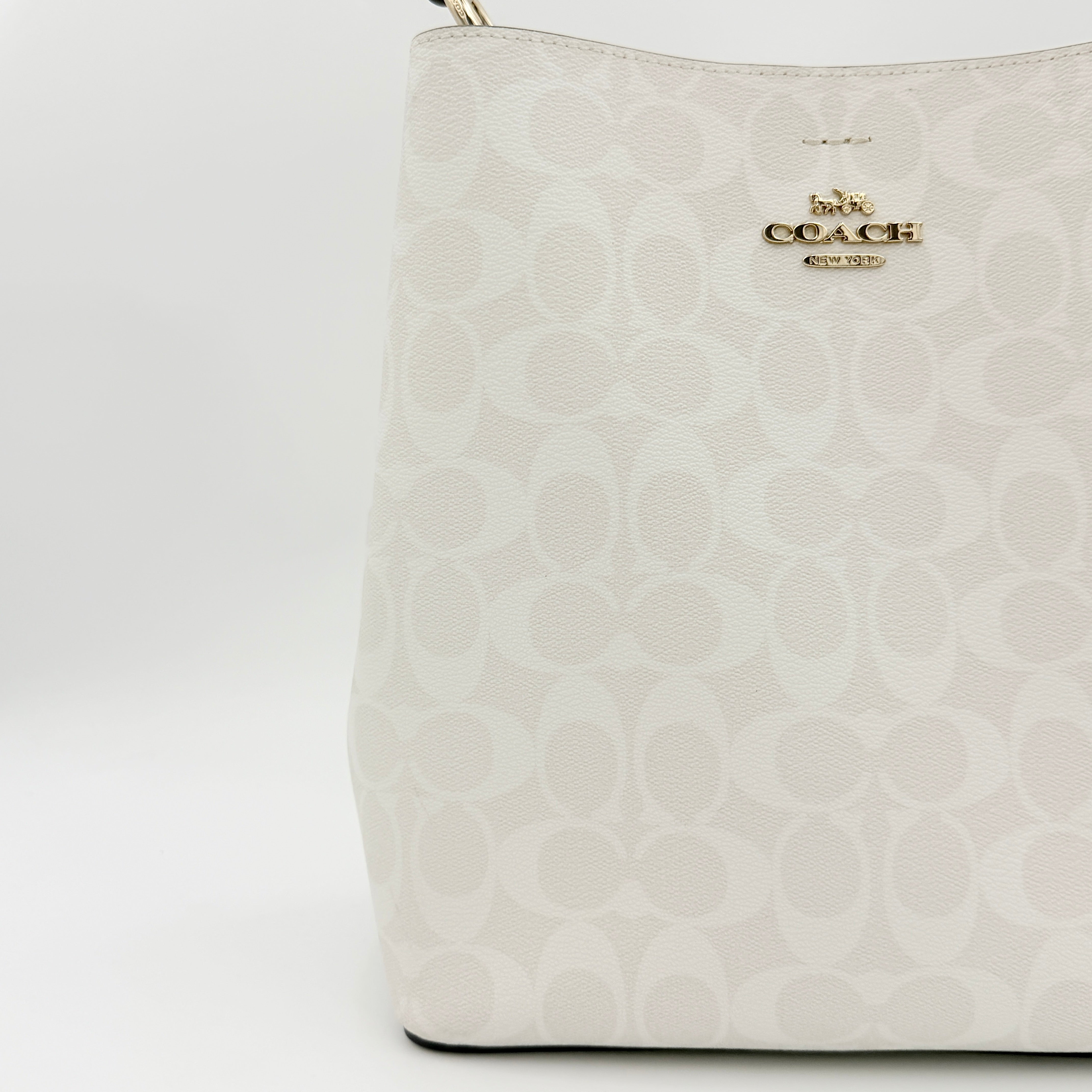 Coach Signature Town Bucket Shoulder Bag in white monogram canvas, shown with detachable strap and gold-tone hardware.