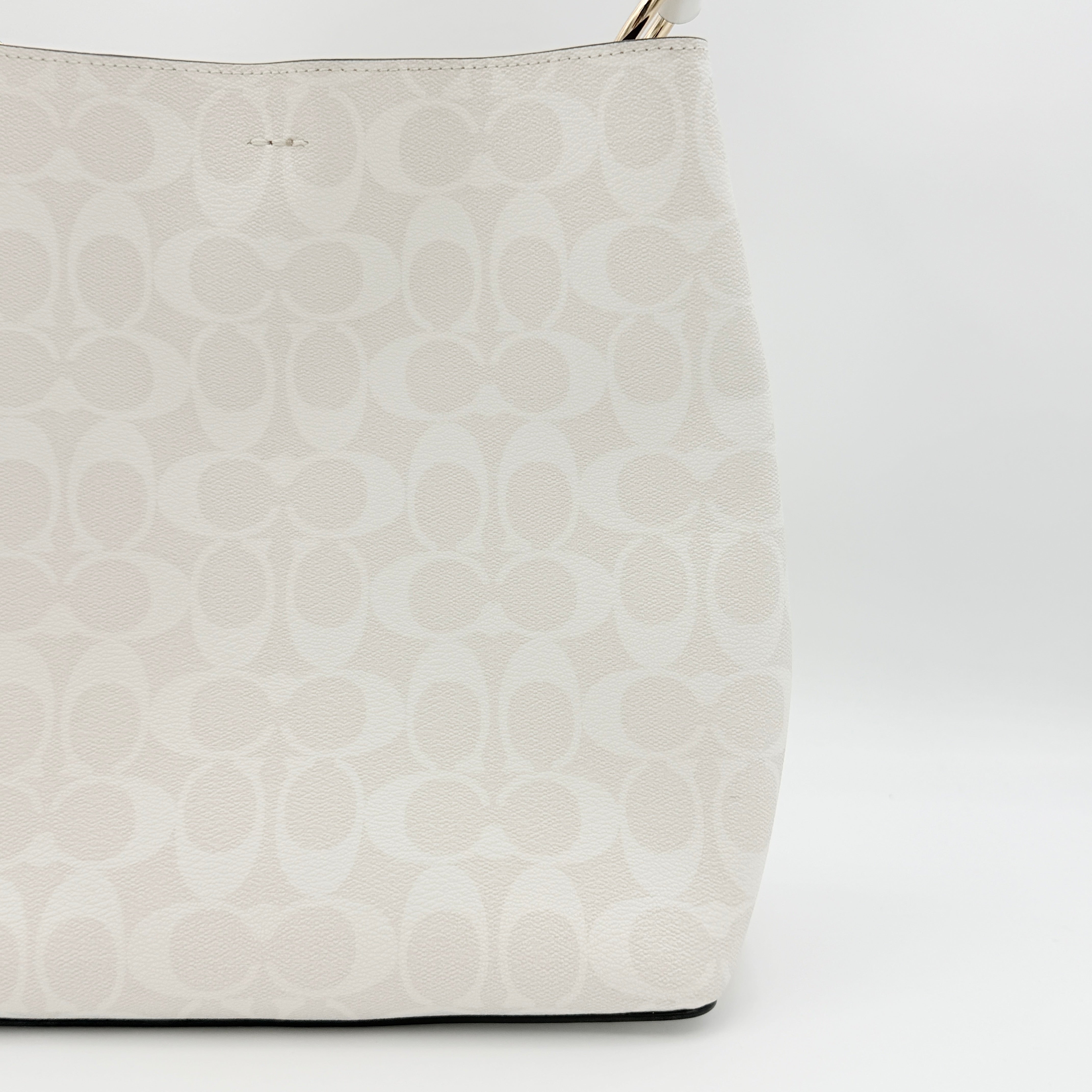Coach Signature Town Bucket Shoulder Bag in white monogram canvas, shown with detachable strap and gold-tone hardware.