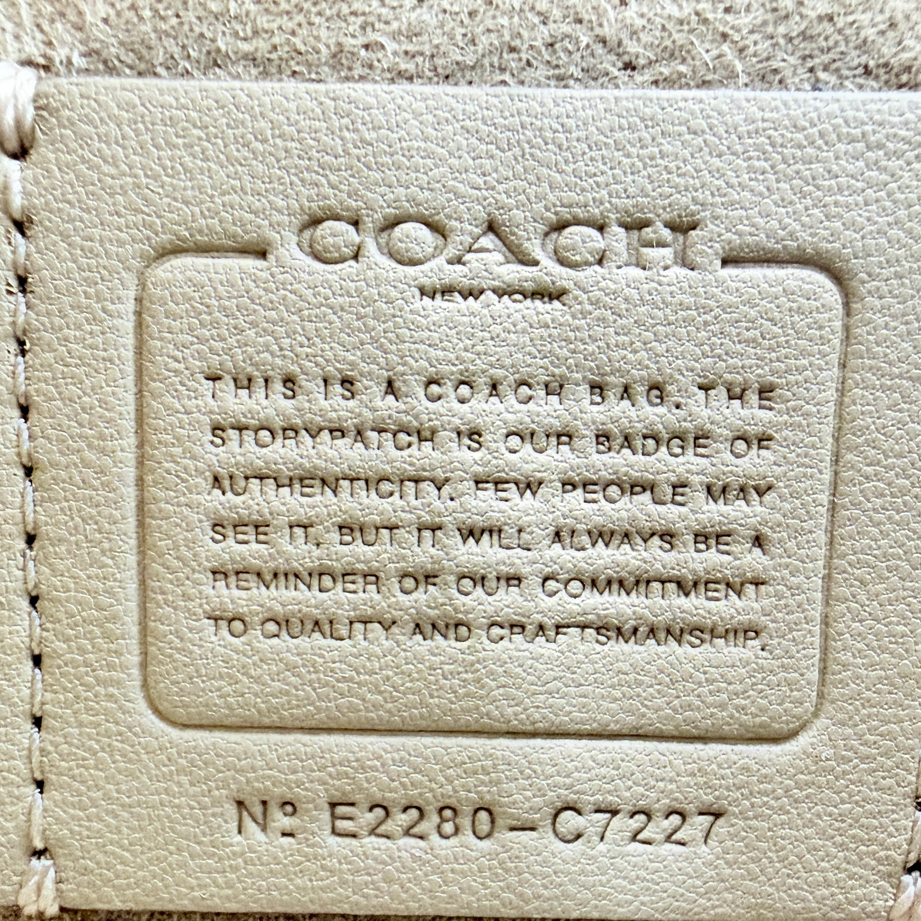 Coach Mini Pepper HandBag in beige canvas with white leather and snakeskin-effect handle, styled with detachable crossbody strap.