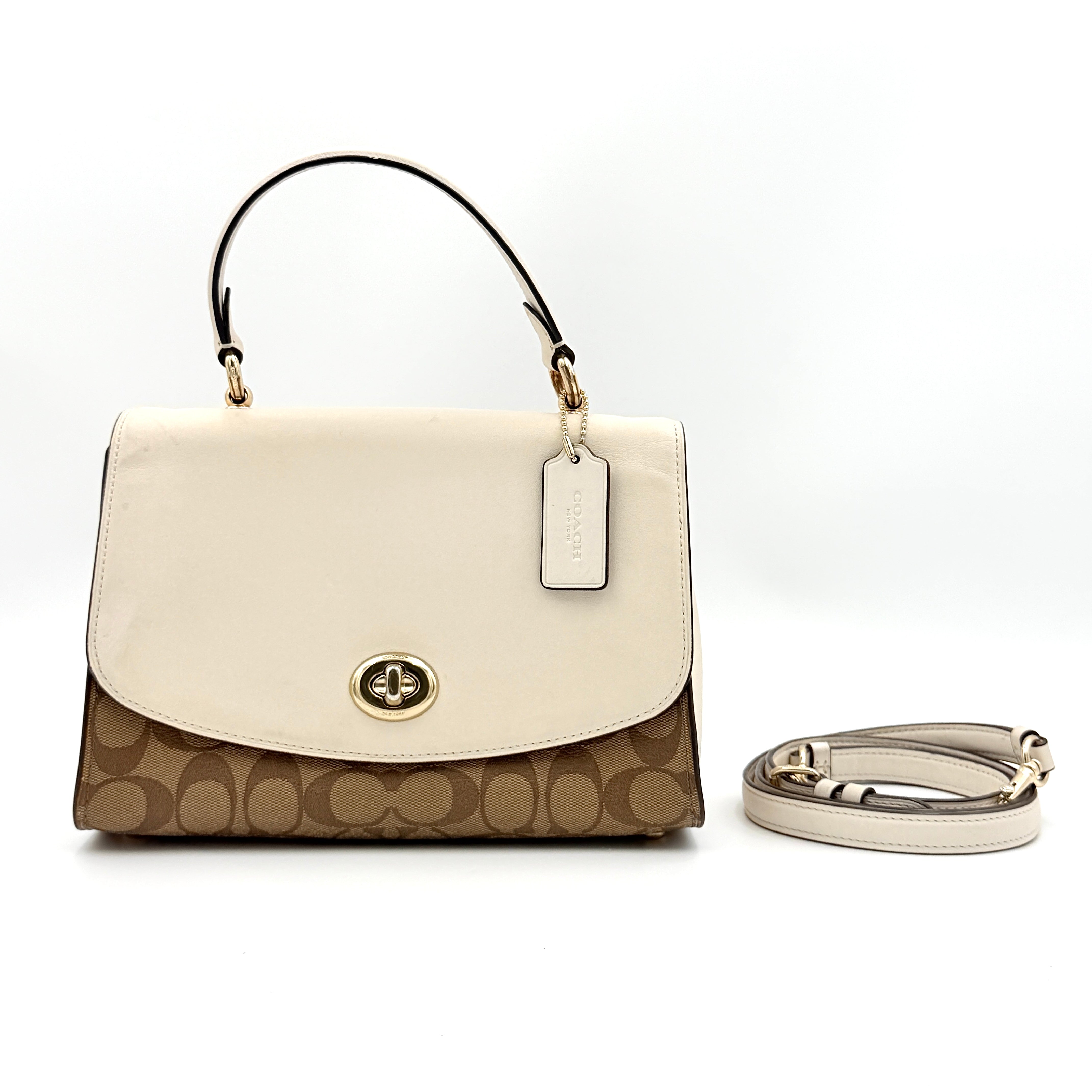 Coach Signature Tilly Top Handle Bag in beige and white with gold-tone hardware and detachable strap, displayed against a clean background.