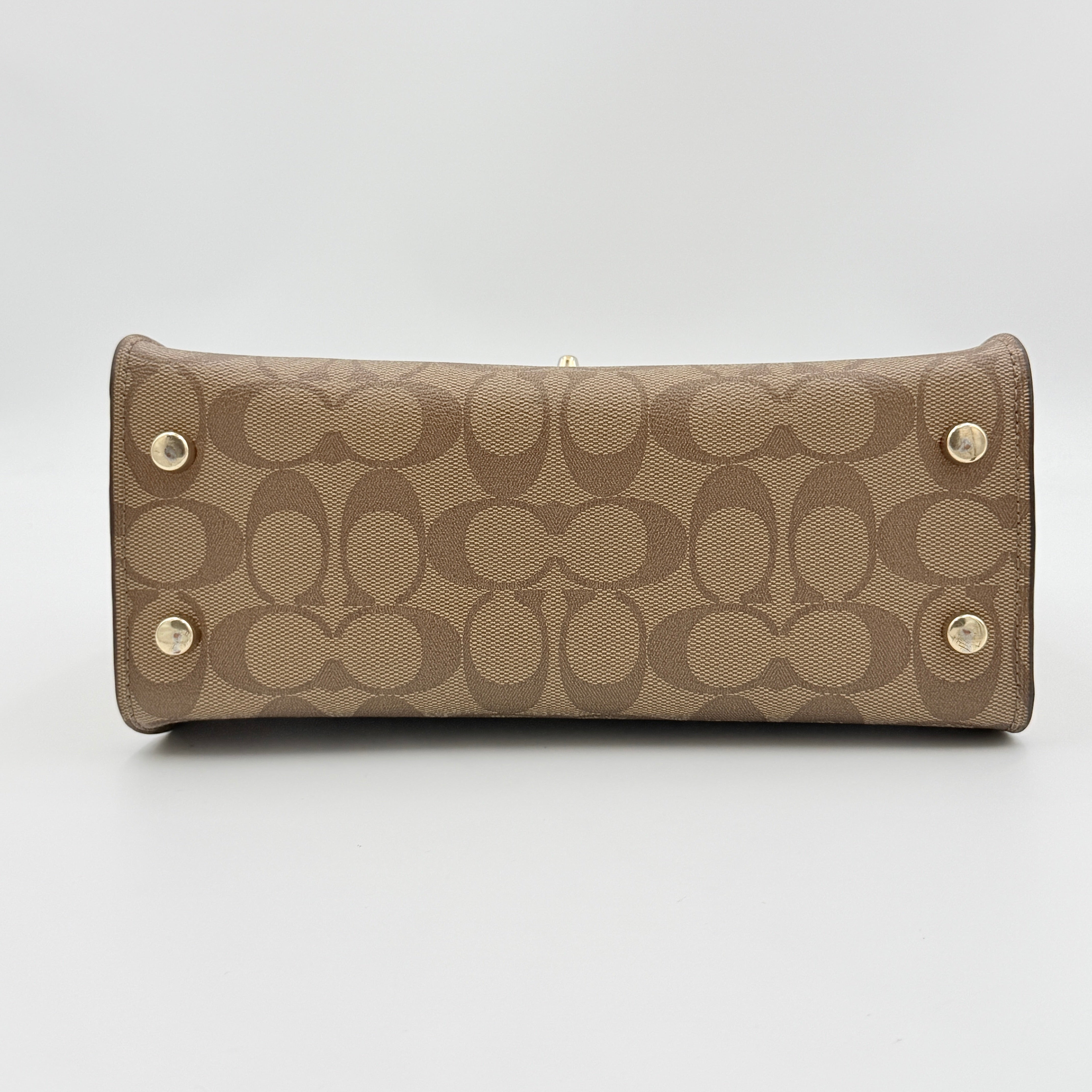 Coach Signature Tilly Top Handle Bag in beige and white with gold-tone hardware and detachable strap, displayed against a clean background.