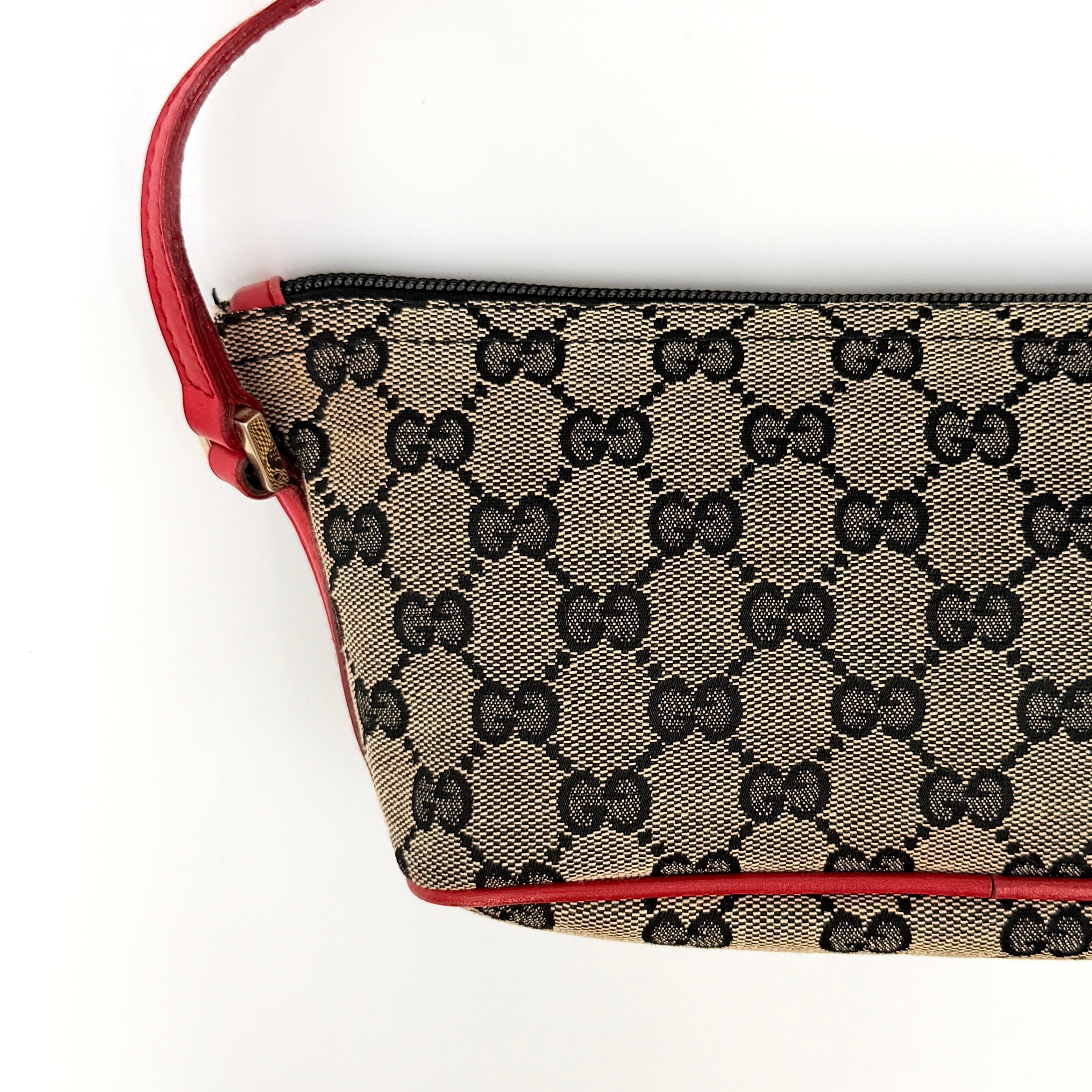 Gucci GG Monogram Pochette Boat Shoulder Bag in grey canvas with red leather trim and gold plaque, shown against a plain background.