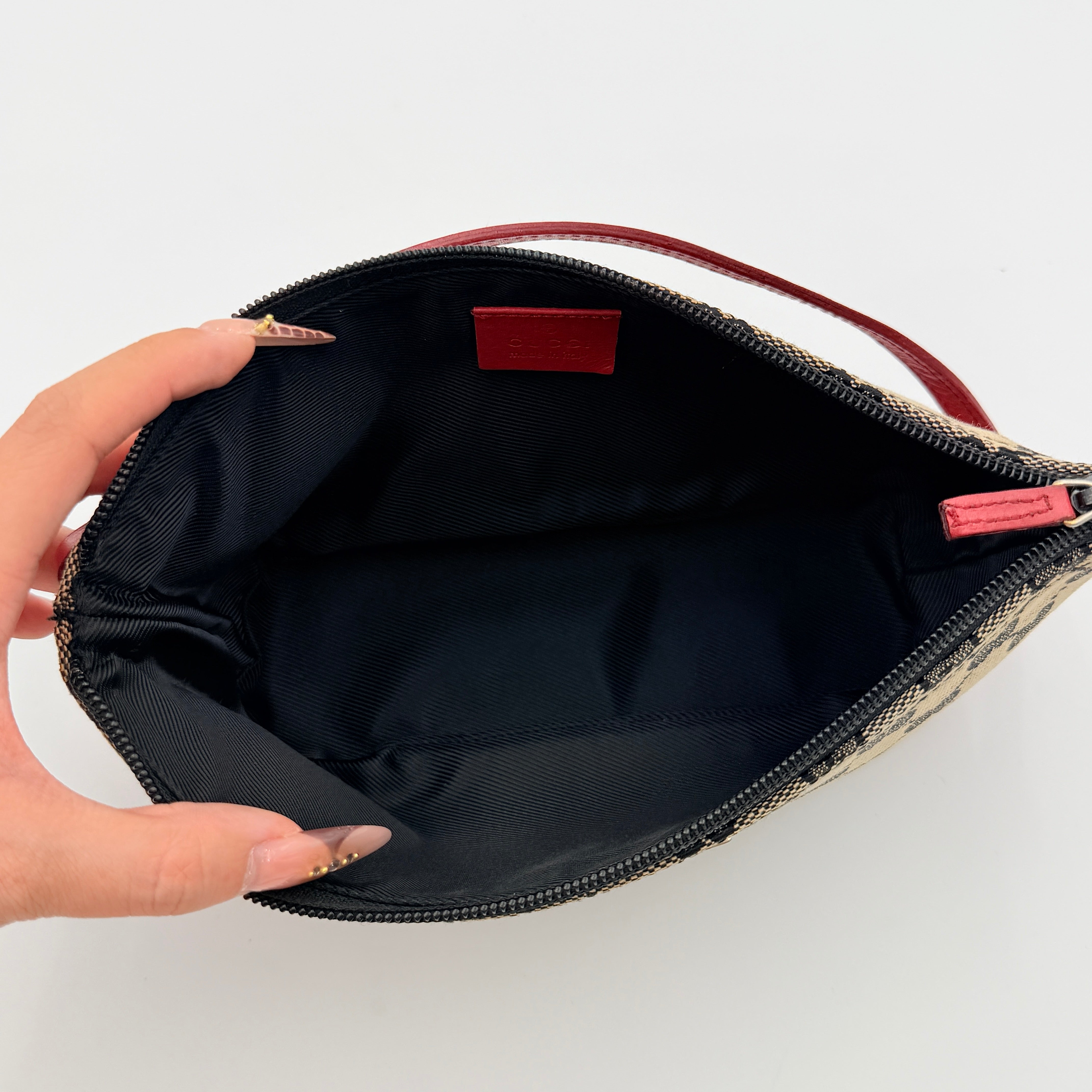 Gucci GG Monogram Pochette Boat Shoulder Bag in grey canvas with red leather trim and gold plaque, shown against a plain background.