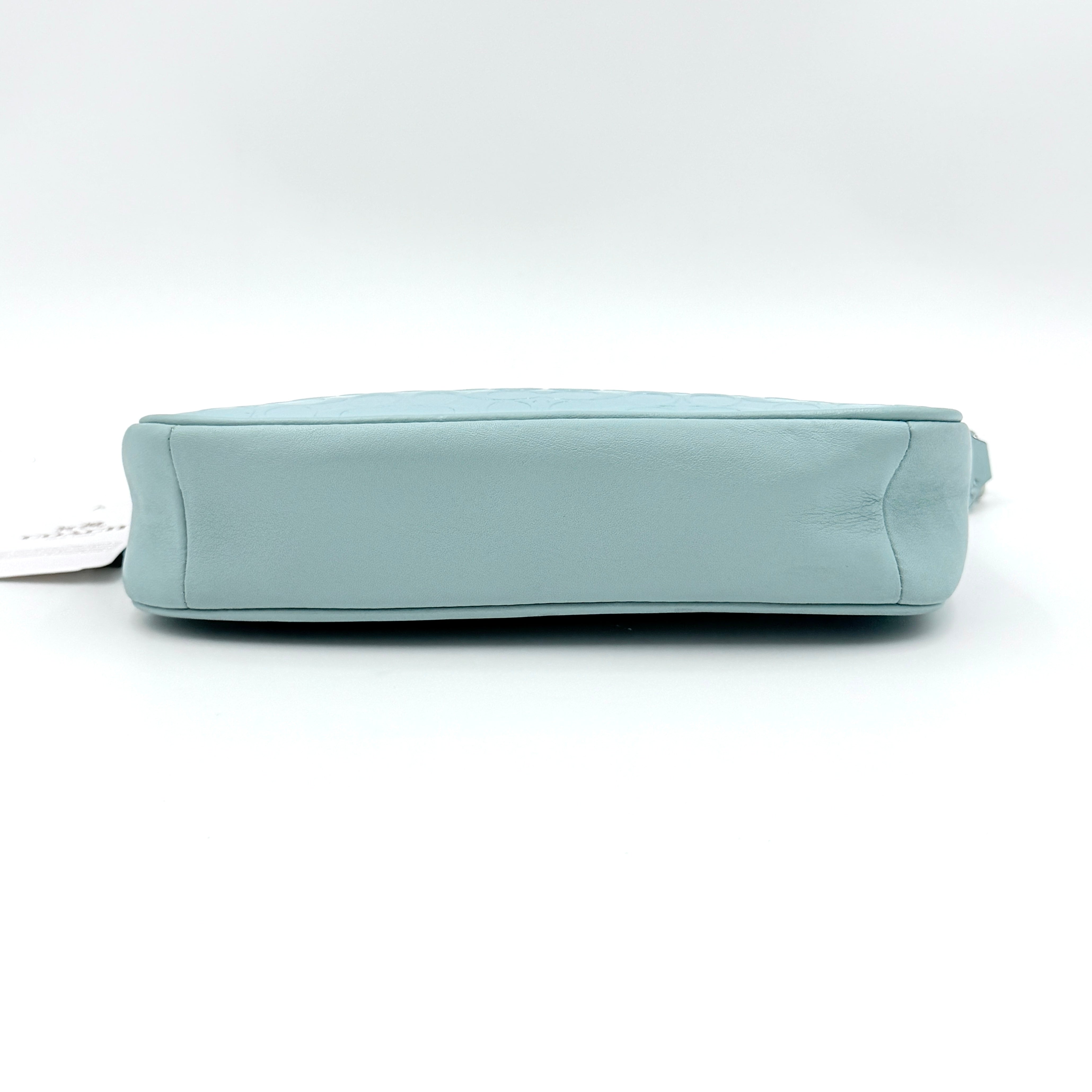 Coach Nolita 19 small shoulder bag in light blue embossed patent leather with silver-tone chain strap shown against a white background.