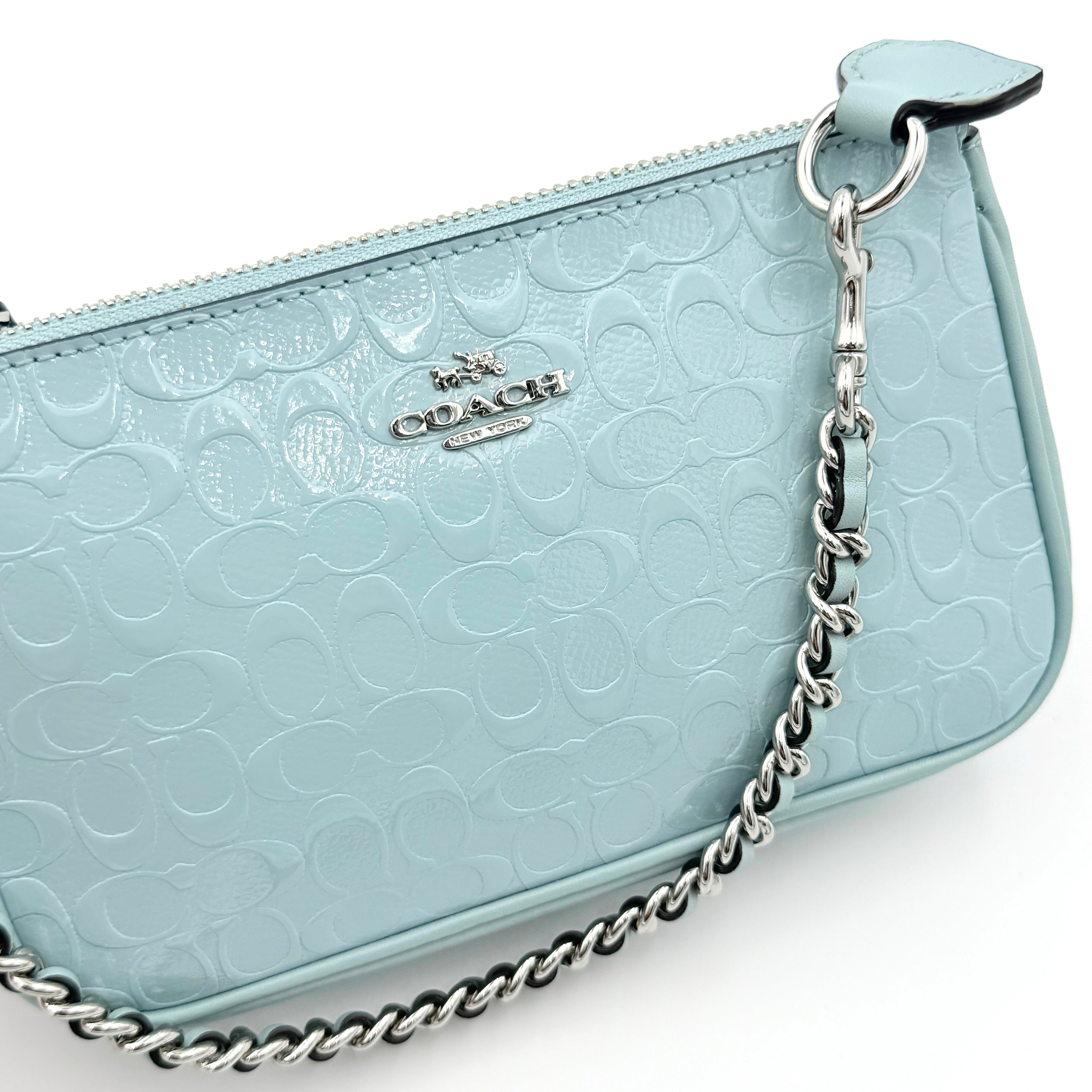 Coach Nolita 19 small shoulder bag in light blue embossed patent leather with silver-tone chain strap shown against a white background.