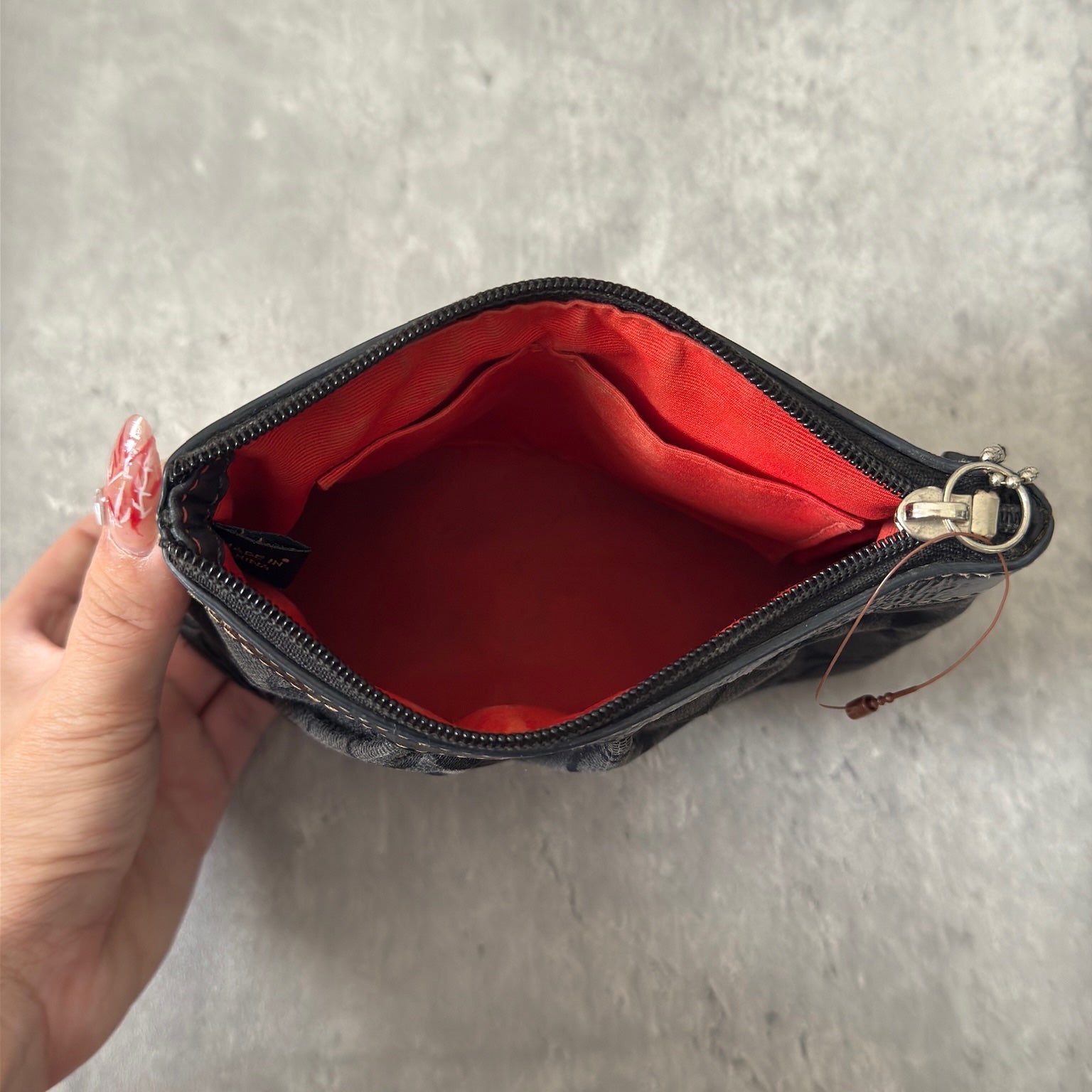 Coach Signature Pleated Black Wristlet with iconic monogram pattern, black leather trim, and red fabric interior, vintage condition.